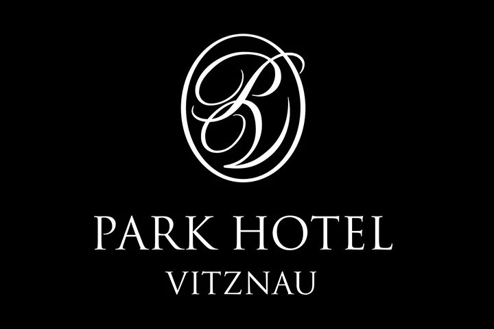 Logo des Park Hotels Vitznau, weiß auf schwarzem Hintergrund, mit einem geschnörkelten Buchstaben 'P' und 'D' in Oval.