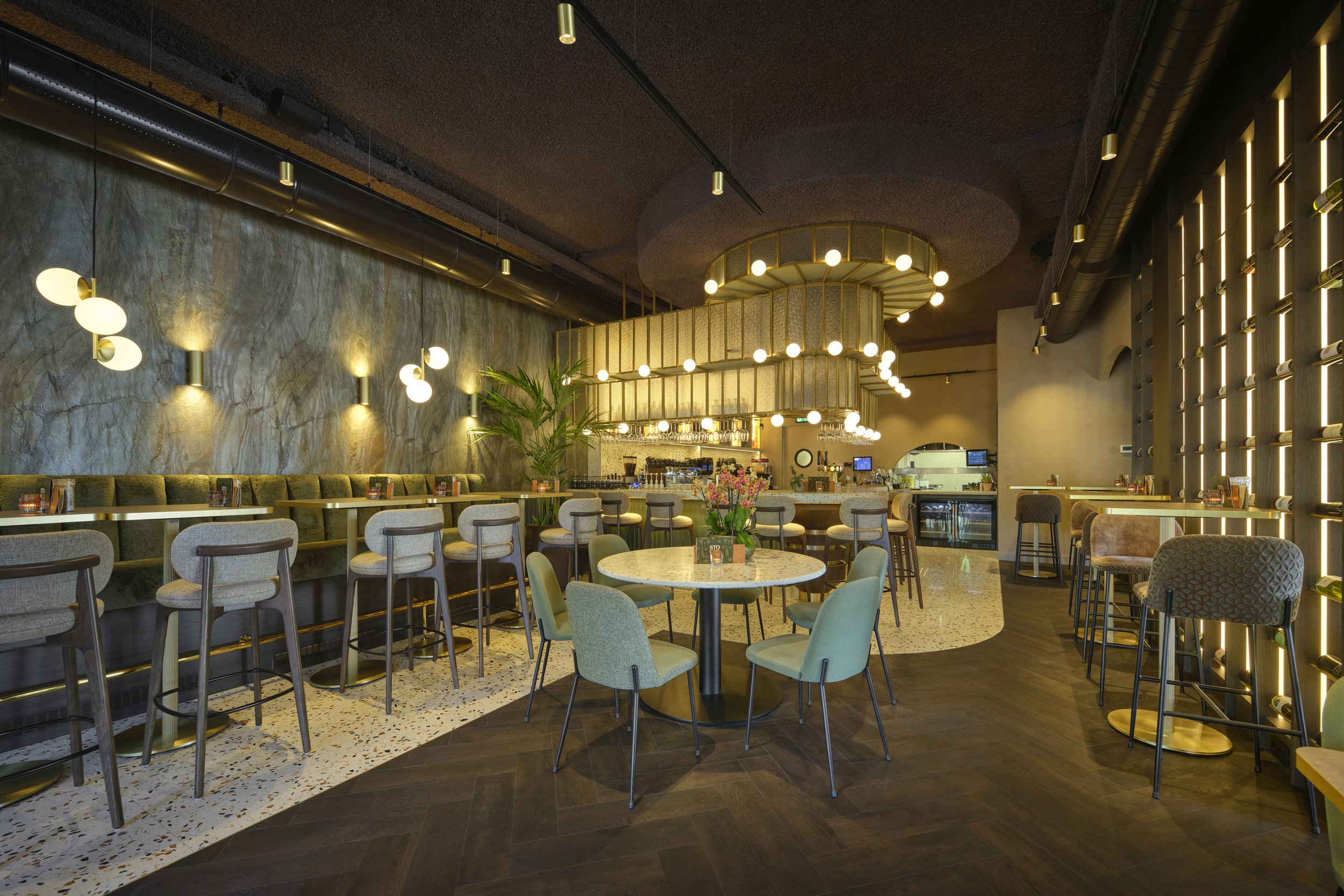 Interieur van een modern café of restaurant met ronde en hoge tafels, geplaatste stoelen en zachte verlichting.