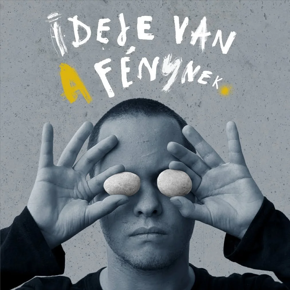 Az Ideje van a fénynek, a Baltazár Színház és az Artus közös előadásának kampányképe: egy férfi két követ tart a szeme elé.