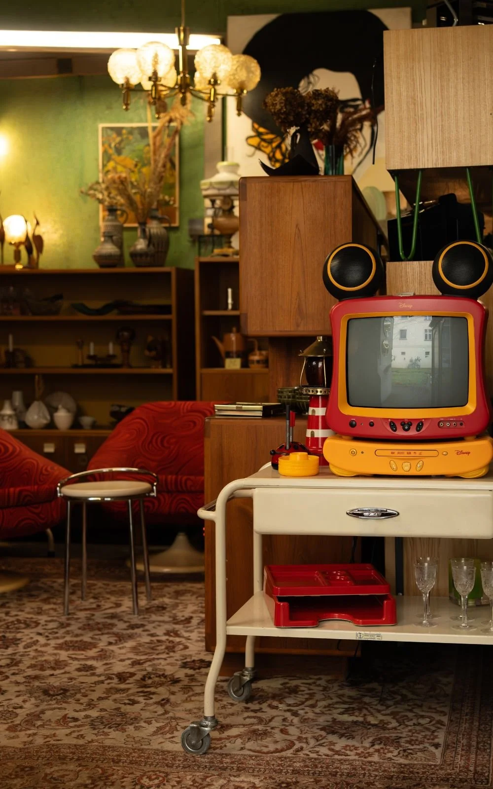 Vintage Haushaltsgegenstände und Möbel arrangiert im warmen Interieur eines kuratierten Stores