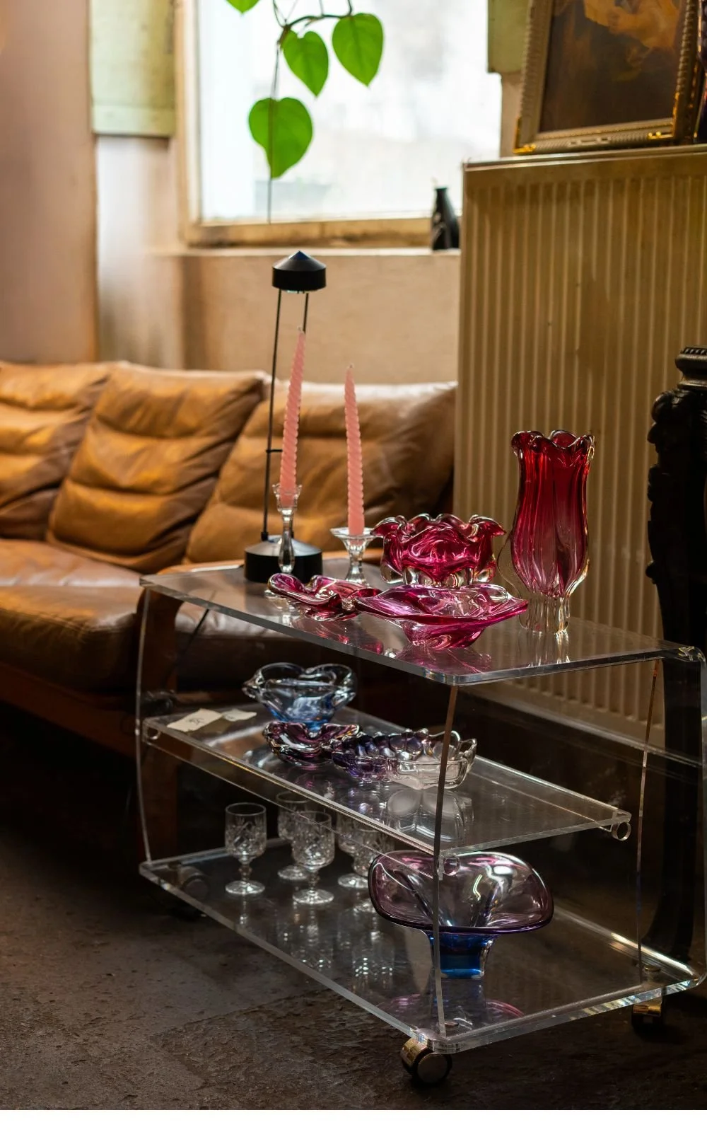 Vintage Couchtisch mit Glasobjekten und Kerzen in ruhiger Wohnszene im Store