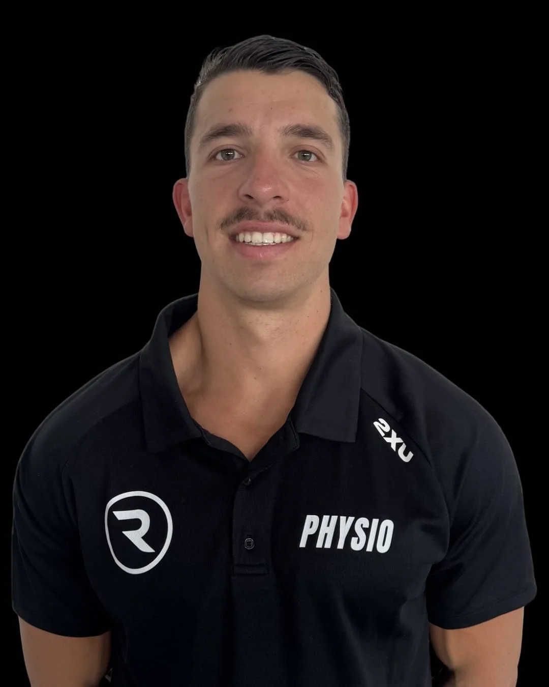 Bailey, wearing a black polo shirt with the word 'PHYSIO' and logos, against a black background.