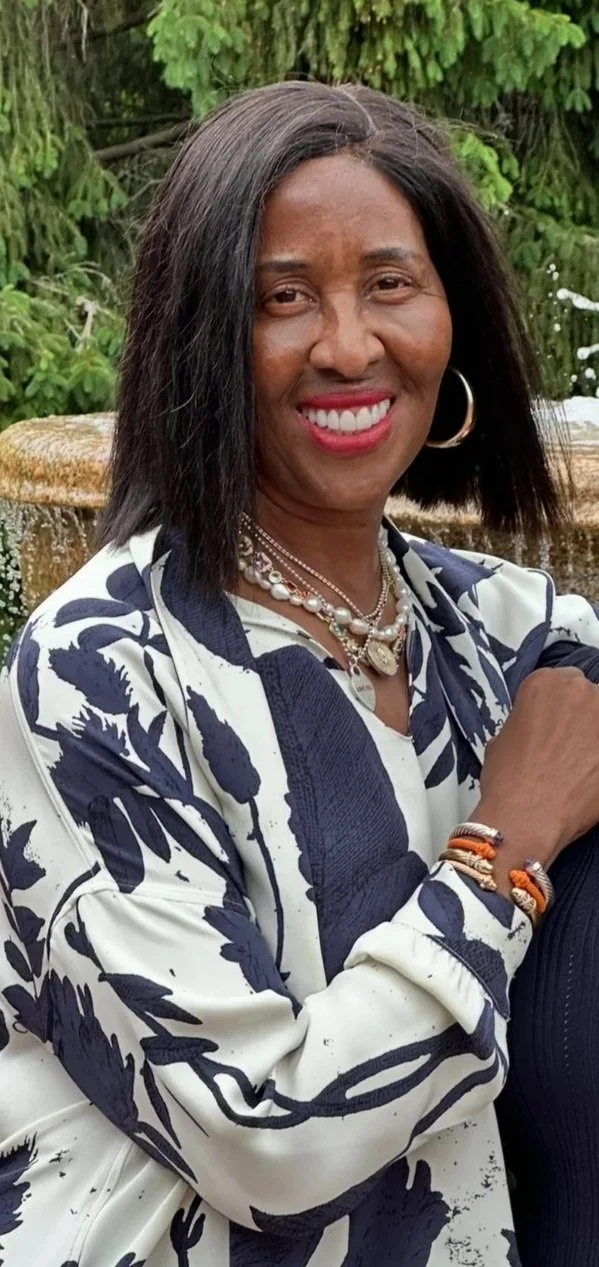 Image of Wonderlyn Murphy, found of ThinkNorth Coaching wearing a blue and white print blouse and gold earrings.