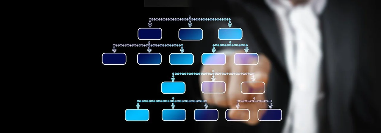 Person pointing at a digital flowchart or organizational chart with blue boxes.