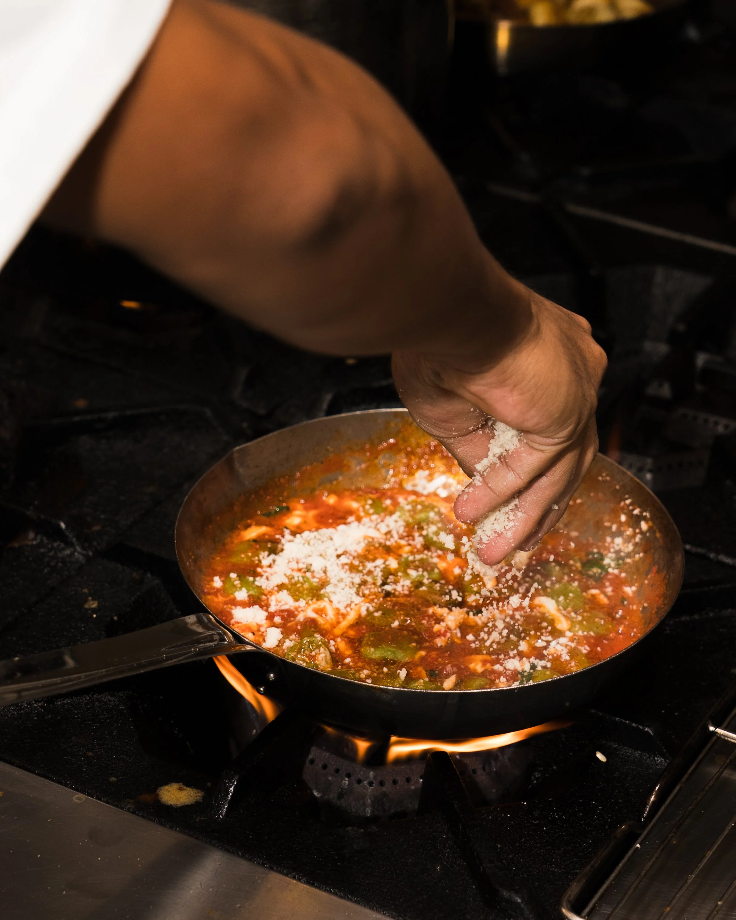 Action shot of a chef seasoning a dish