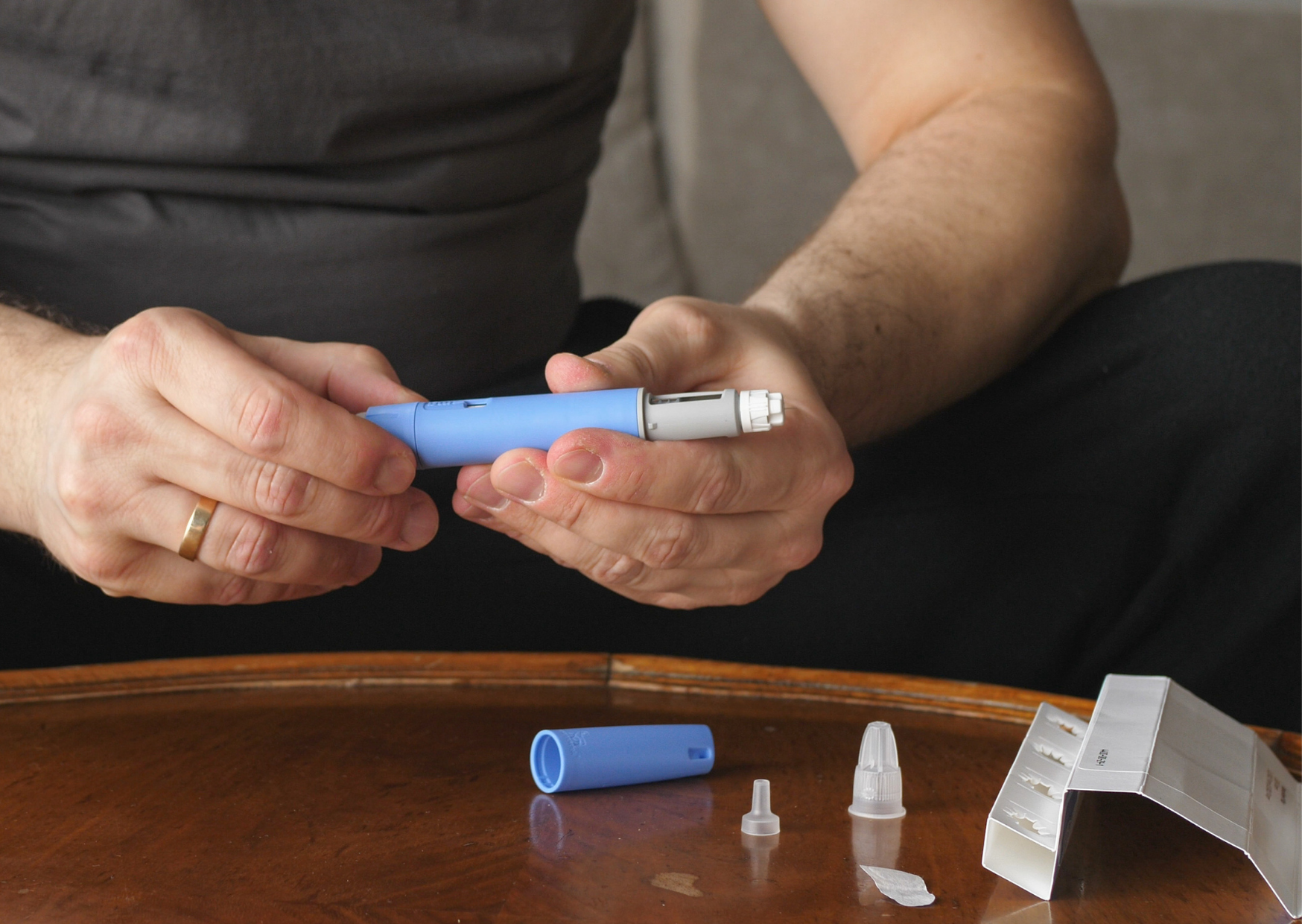 Mies pistää Ozempic-lääkettä vatsan alueelle lääkärin määräämän GLP-1-laihdutushoidon osana