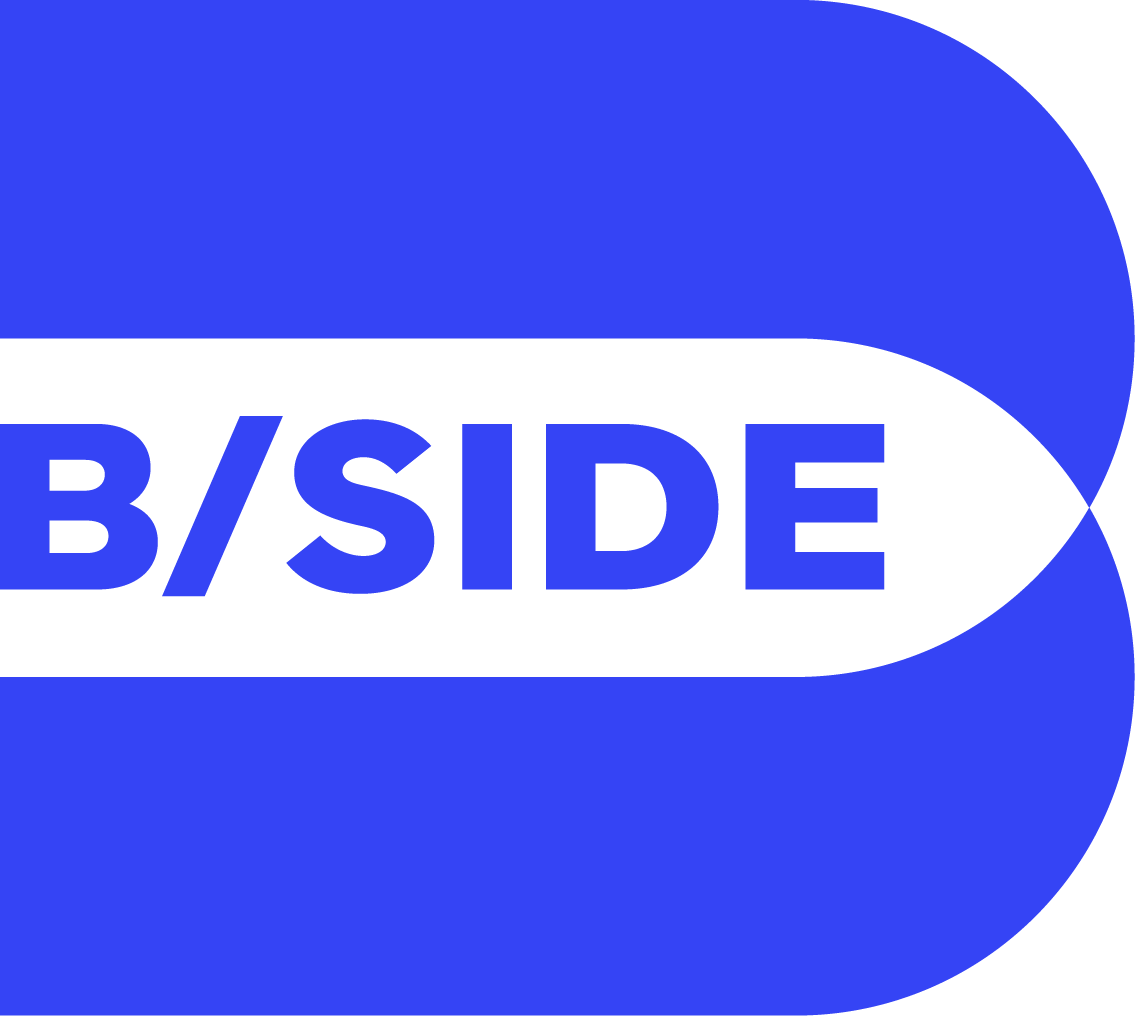 Blue and black logo with the text 'B/SIDE' inside an arrow shape.