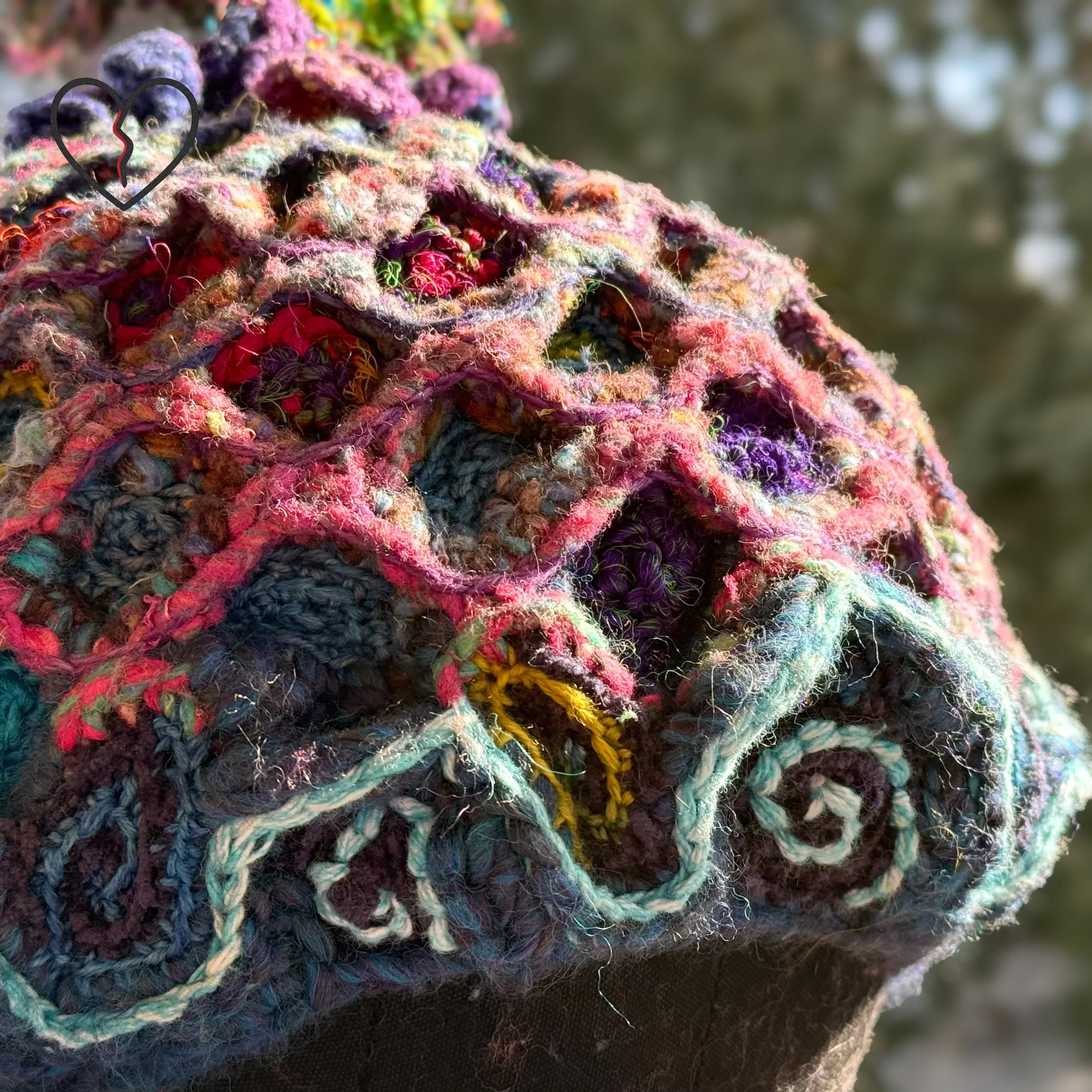 Close detail of sari silk scales within wool lattice Macro texture showing layered crochet scale construction