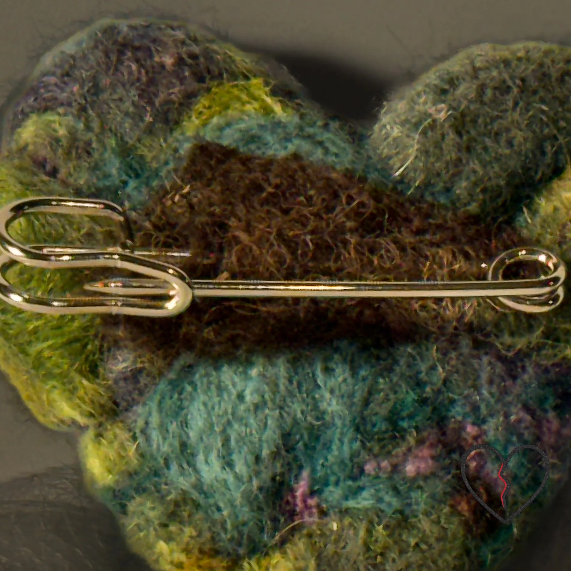 Close-up detail of moss green and purple fiber textures emphasizing cracks and layered wool