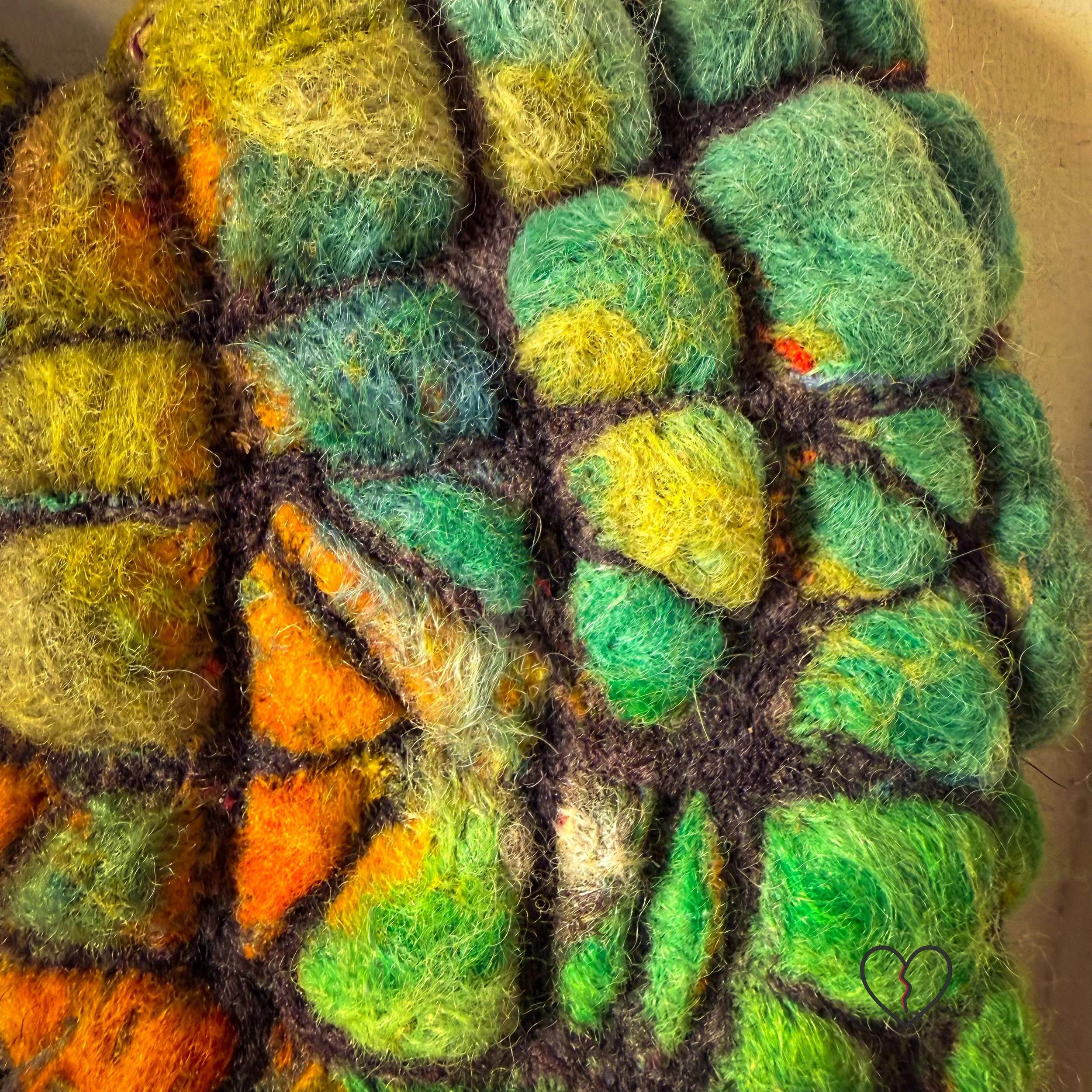 Close-up showing raised texture and layered color in needle felted wool wall art Fractured Landscape.