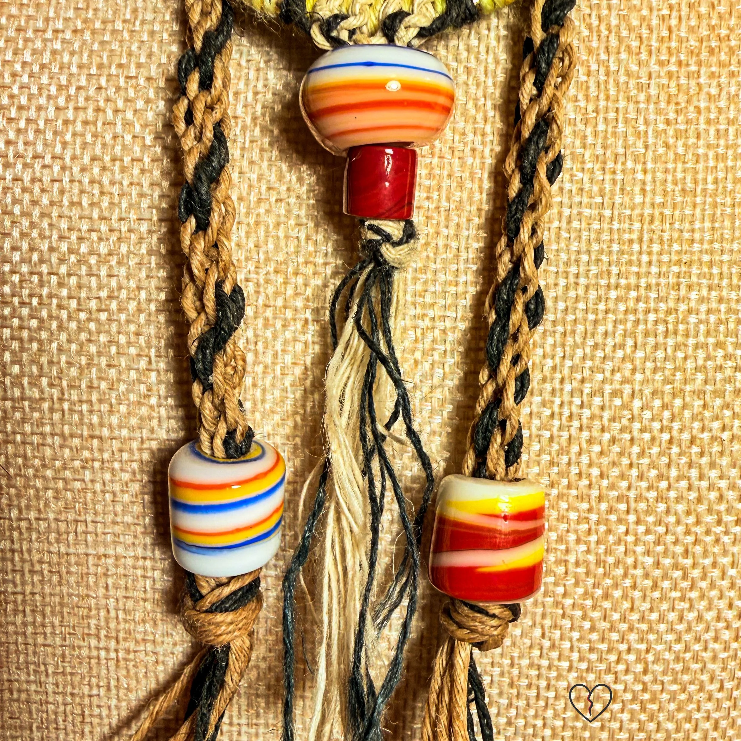 Fiber necklace with circular woven pendant and ceramic beads on kumihimo hemp cord