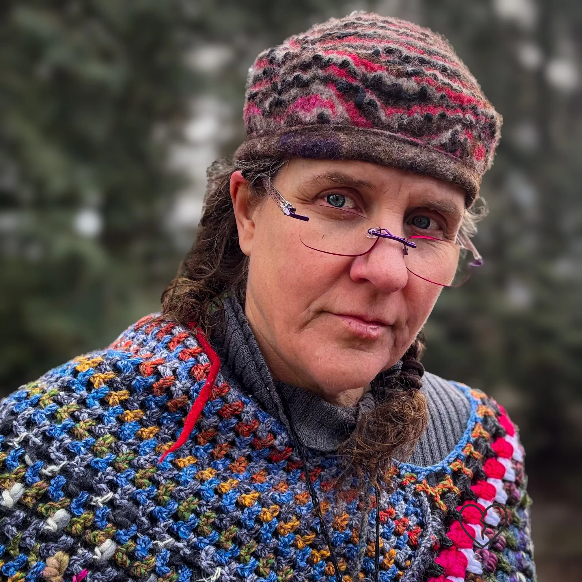 Profile view of a sculptural hand-felted wool hat with organic wave-like stripes in brown, white, and pink merino, resting comfortably above the ear.