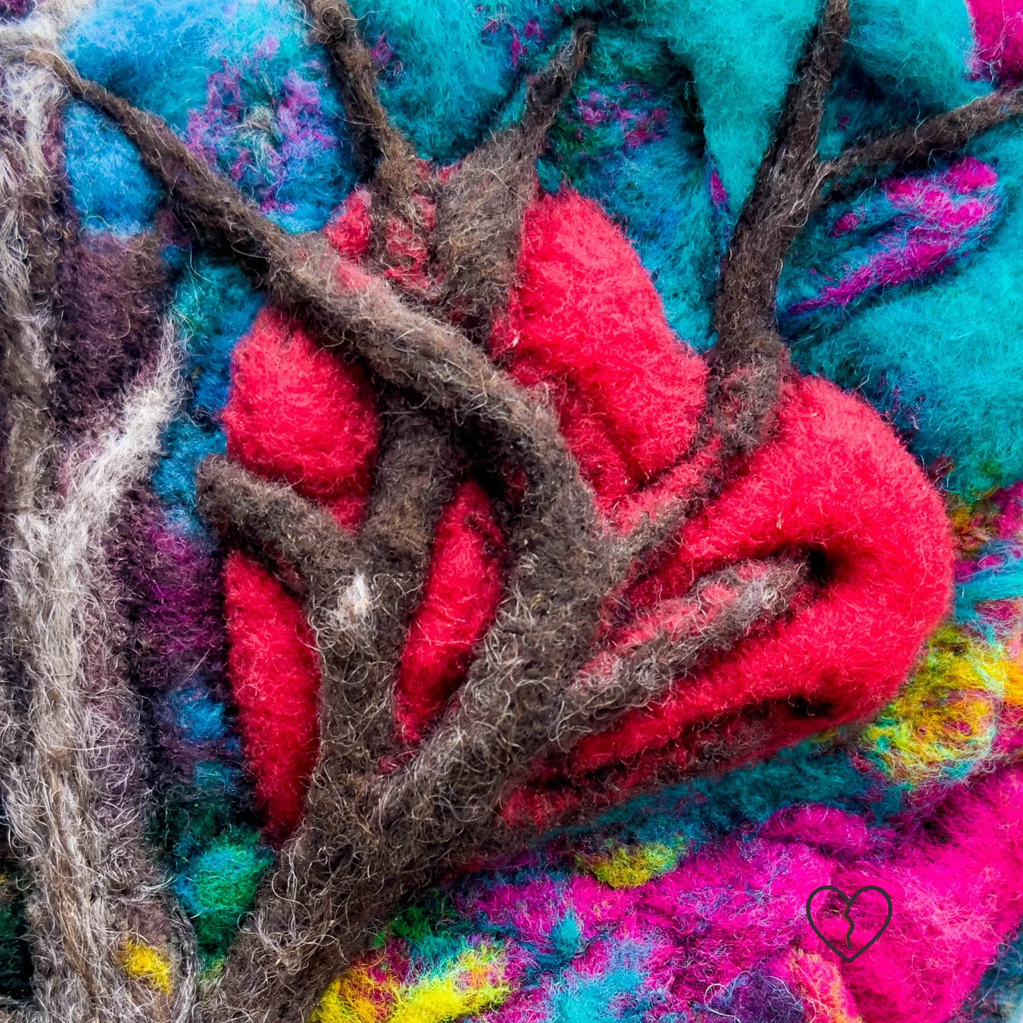 Close-up of needle-felted branches piercing red heart