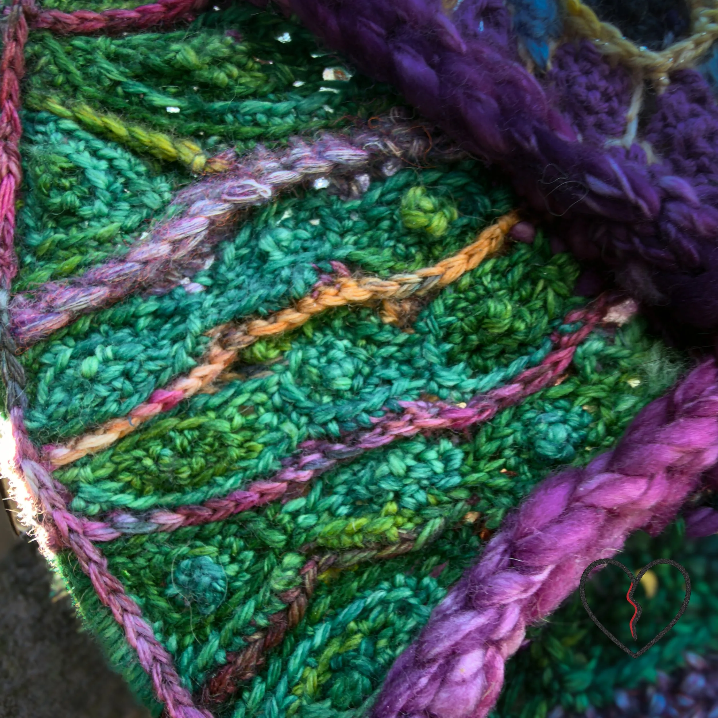 Macro view of hand-dyed green wool crochet with flowing stitch lines suggesting rolling landforms and shared terrain.