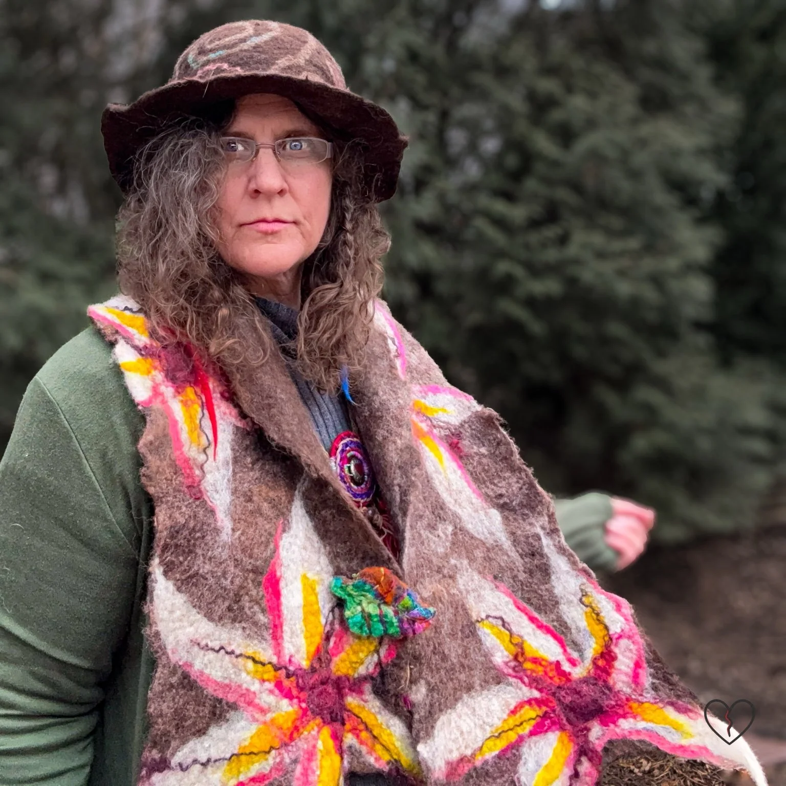 Hand-felted wool scarf worn outdoors, featuring bold floral motifs on natural brown wool