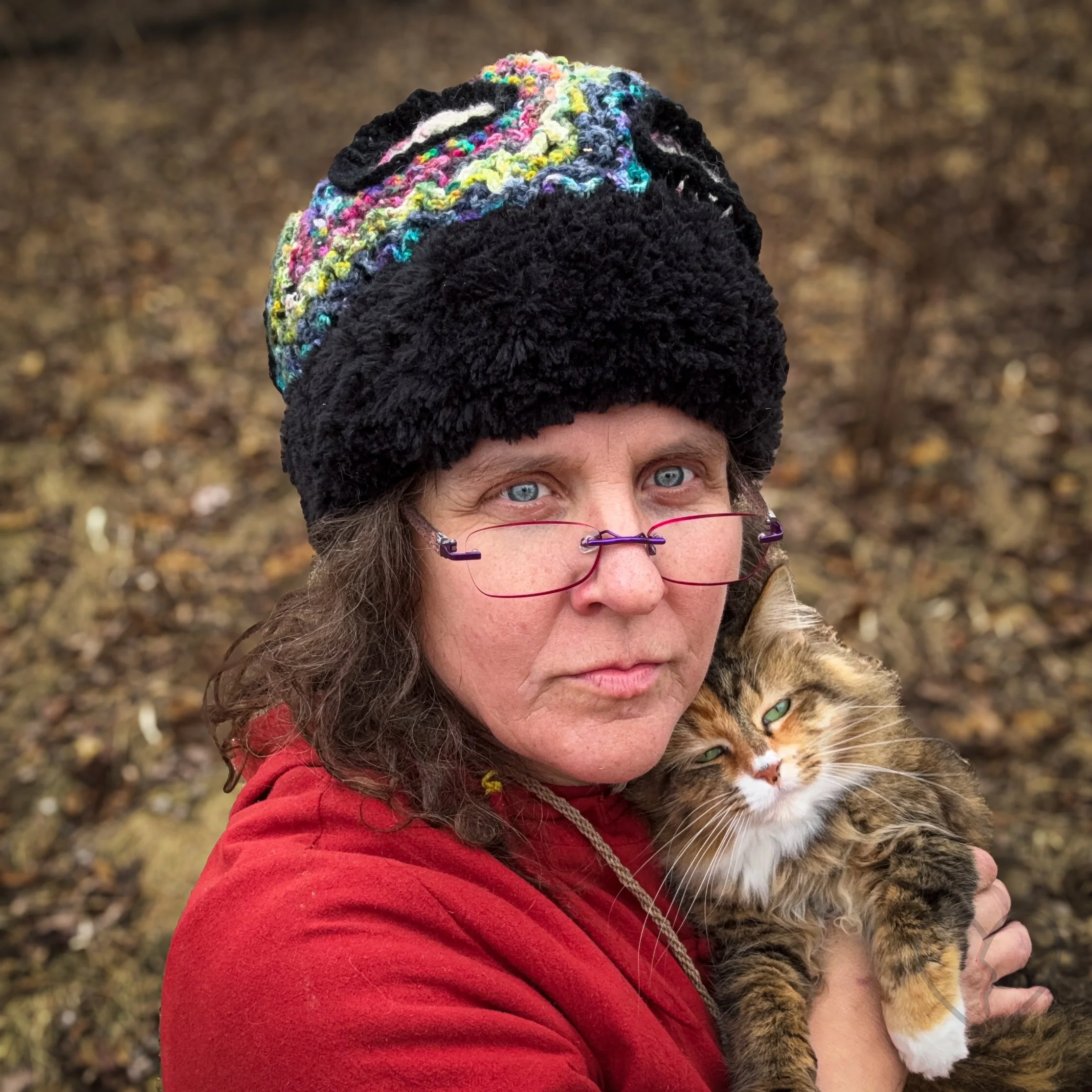 Rippled Cortex is a sculptural freeform crochet wearable art hat by fiber artist Kristi Yapp. Dense layered yarn forms rippling thought pathways surrounding encapsulated memory spirals.