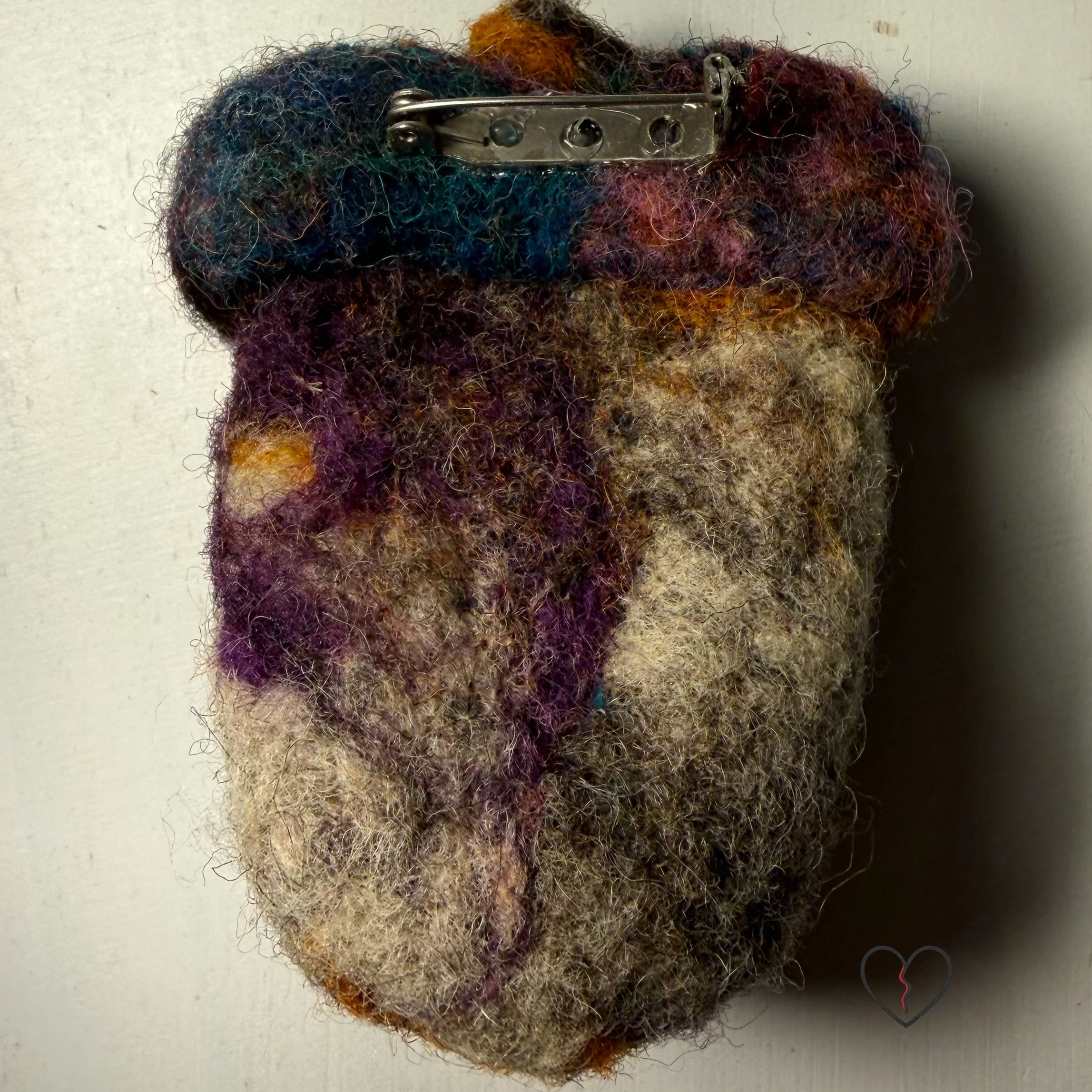 Handmade needle felted wool art pins arranged as a small collection, each approximately two inches square, featuring sculptural forms, layered fiber textures, and earthy, autumn-toned colors.