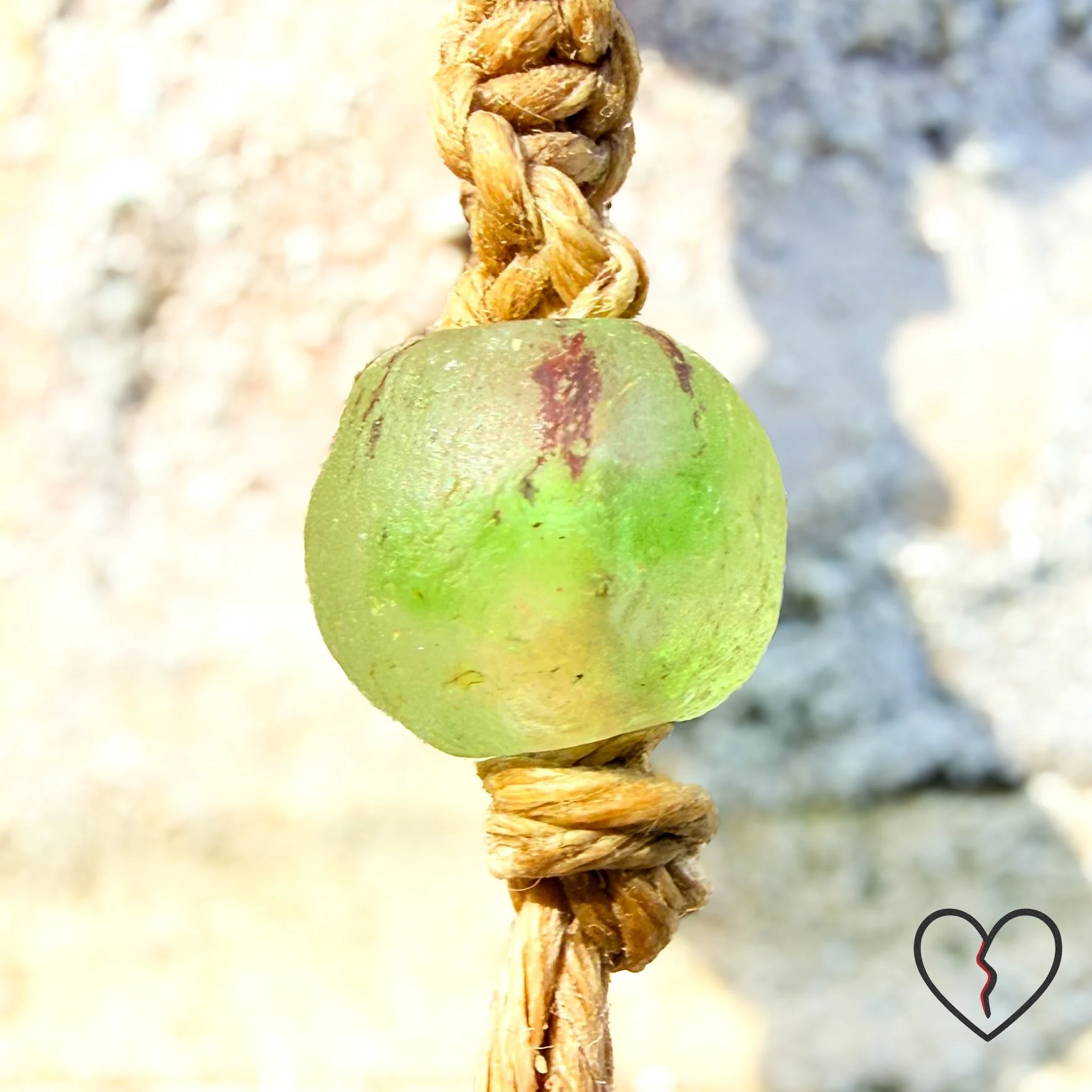 wrapped in sari silk crochet and hemp macrame with glass beads. The piece measures 11 inches long with a 2 inch largest ring and symbolizes triadic balance and transformation.