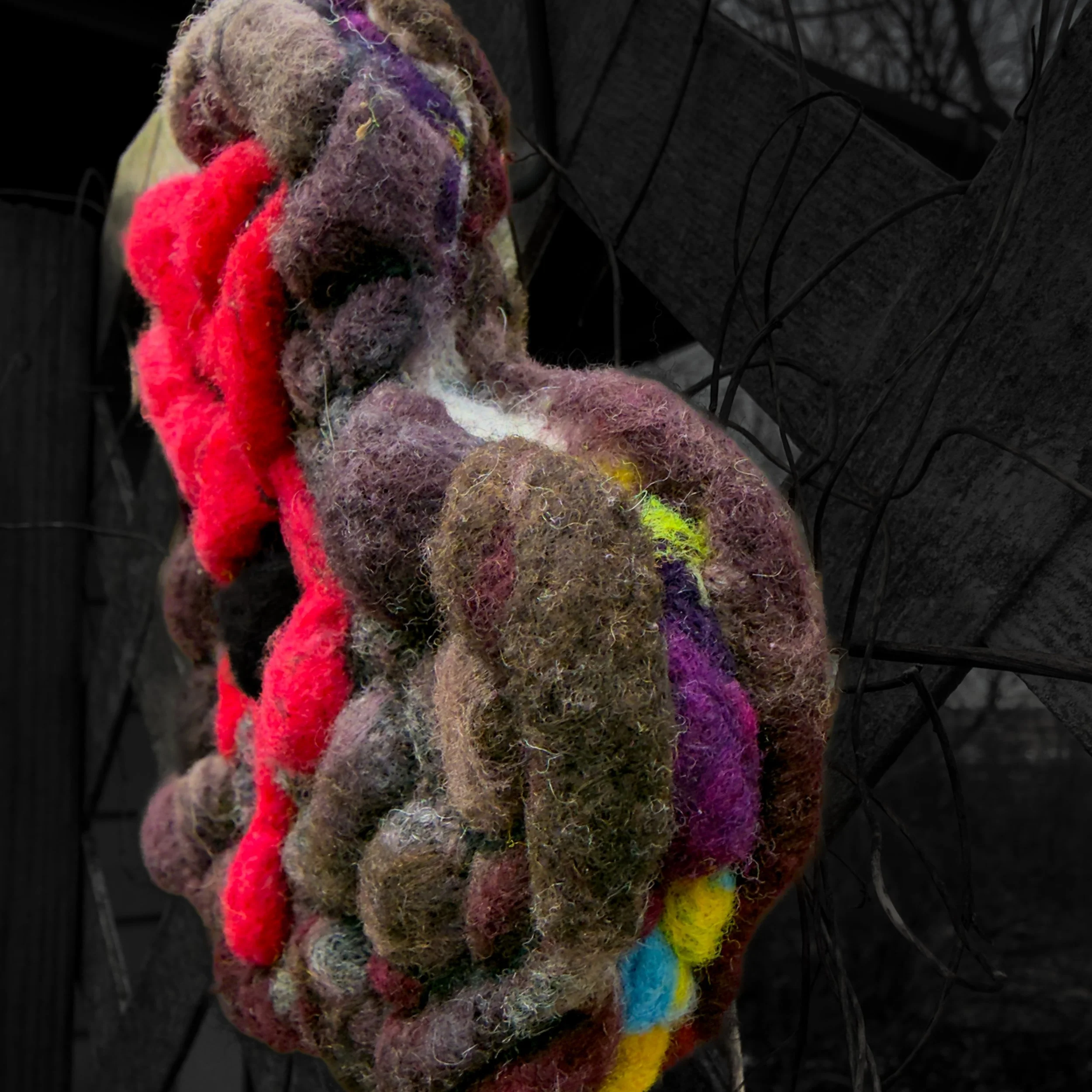 Close-up of scarred red felt heart with visible wounds and black line detailing