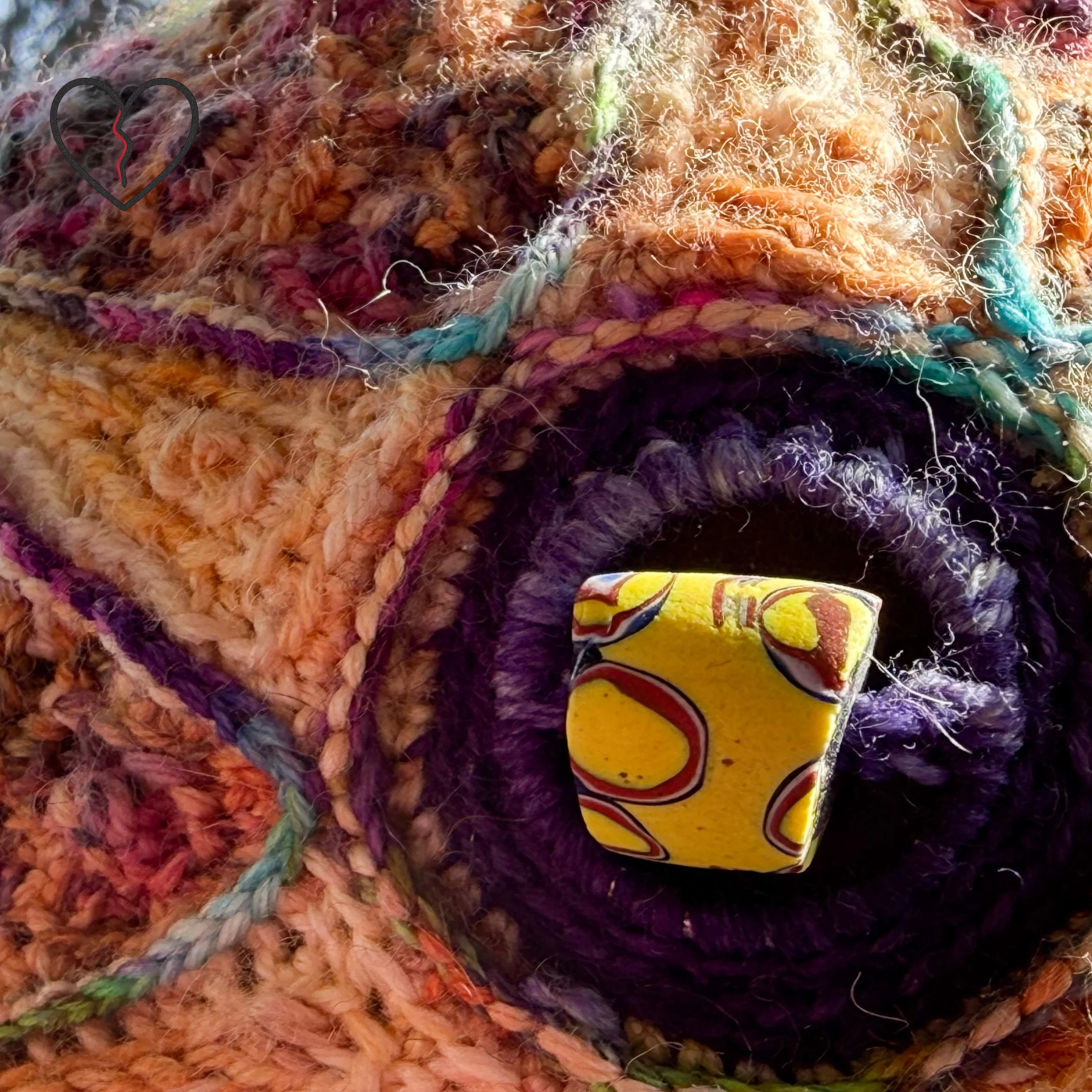 Extreme detail of African trade bead focal point surrounded by radiating stitched sun