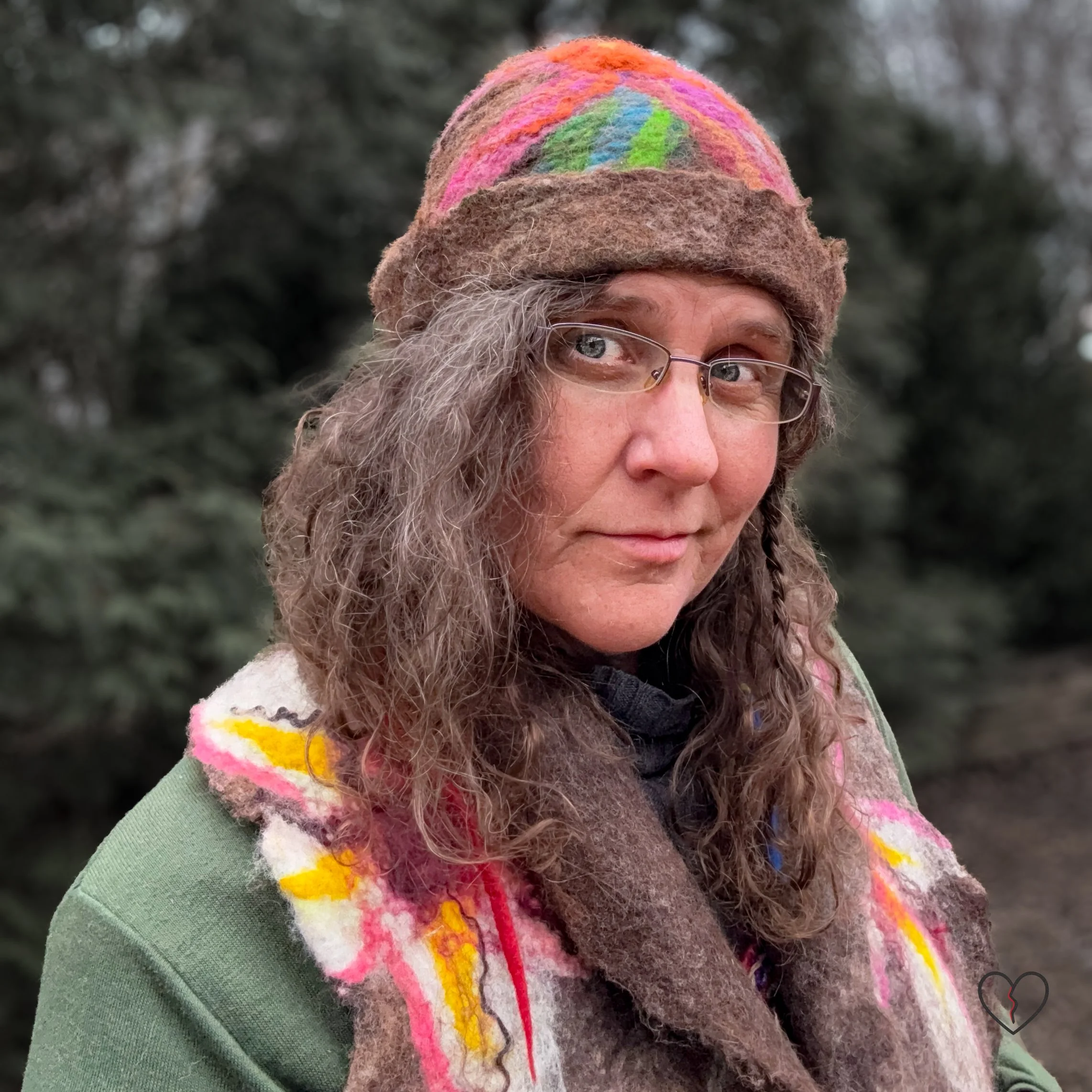 Hand-felted brown wool hat worn outdoors with colorful felted flower on crown