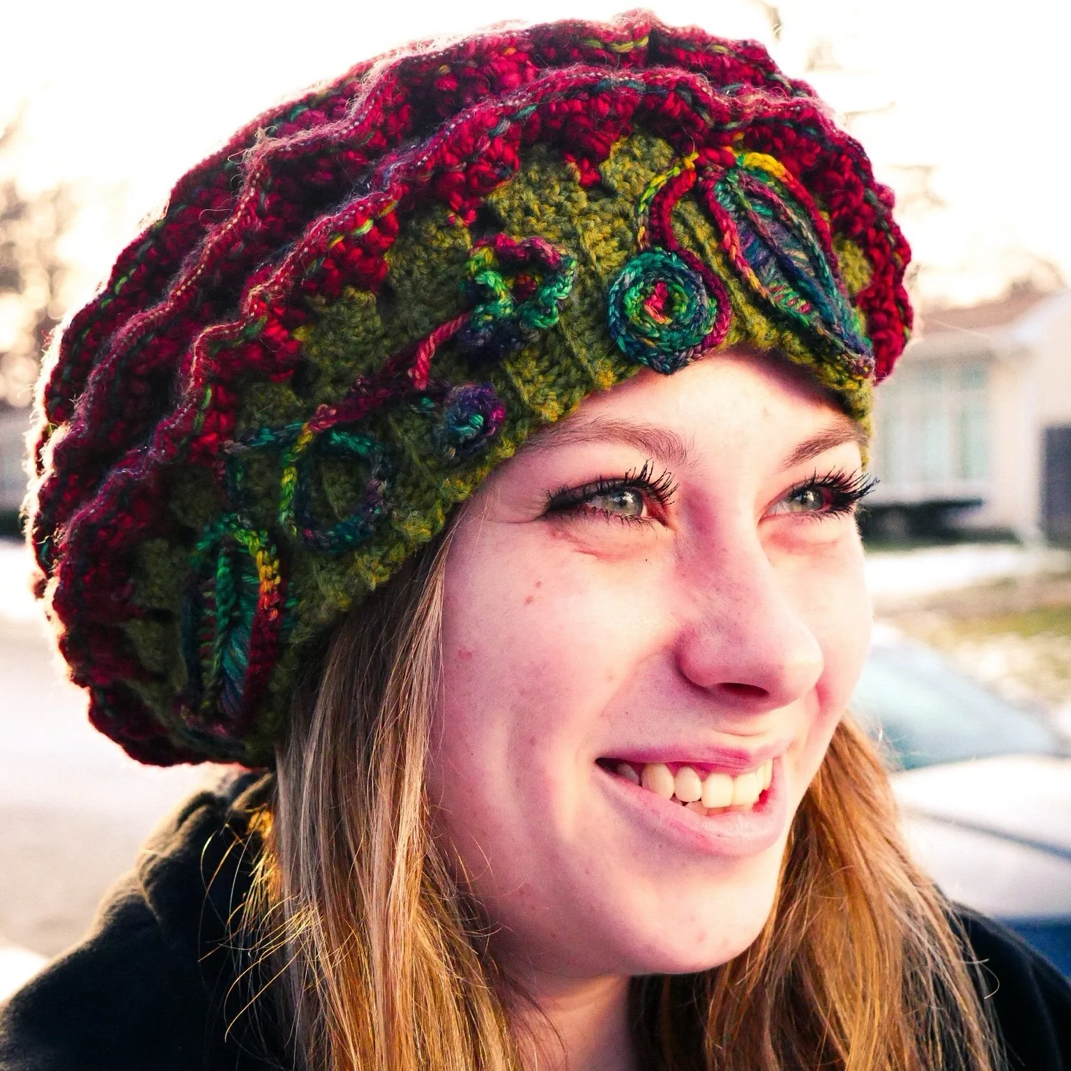 Angled view highlights the sculptural depth of The Cosmic Rose, revealing raised red wool petals and fine prismatic stitching that adds texture and dimensionality.