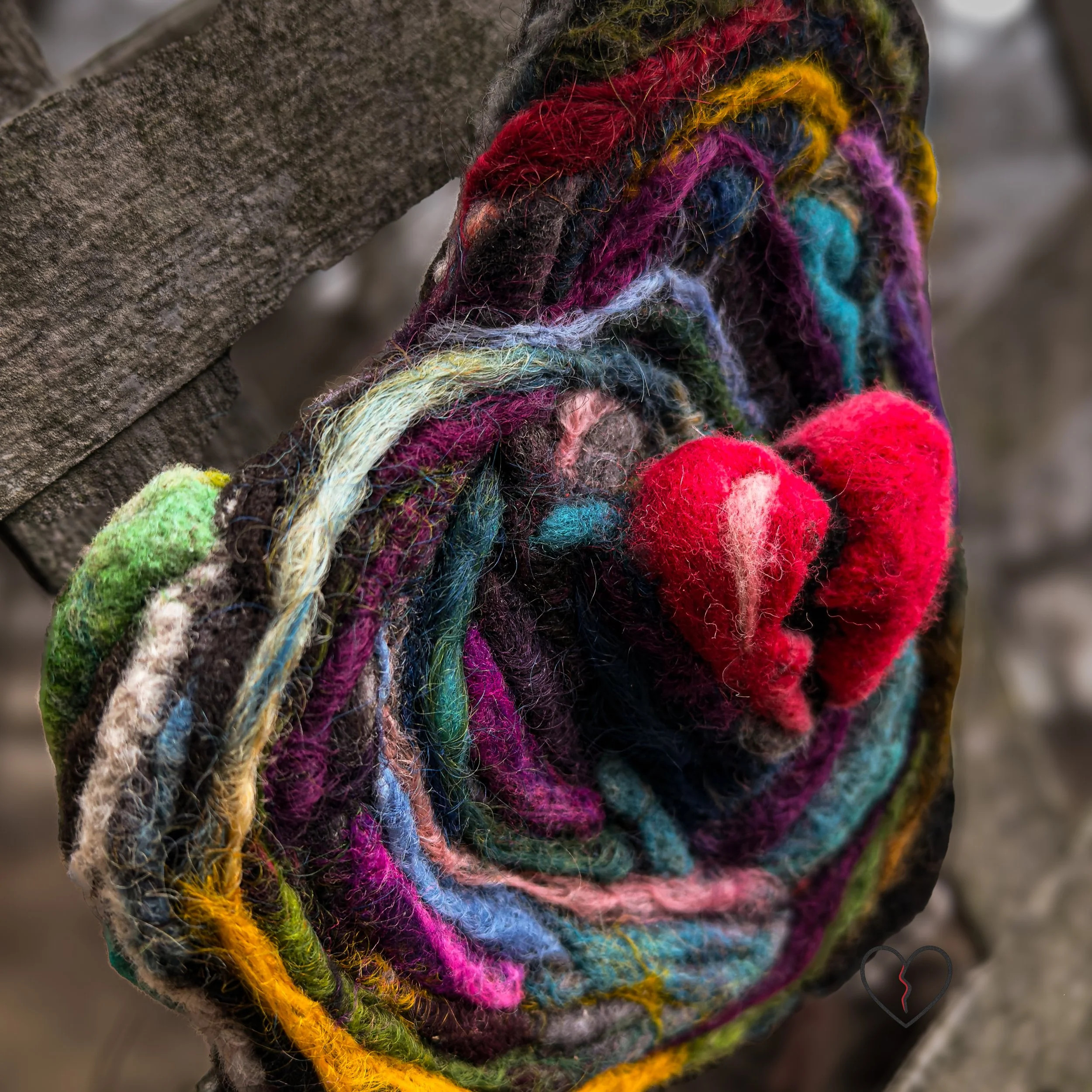 Red felted heart rising from layered wool textures