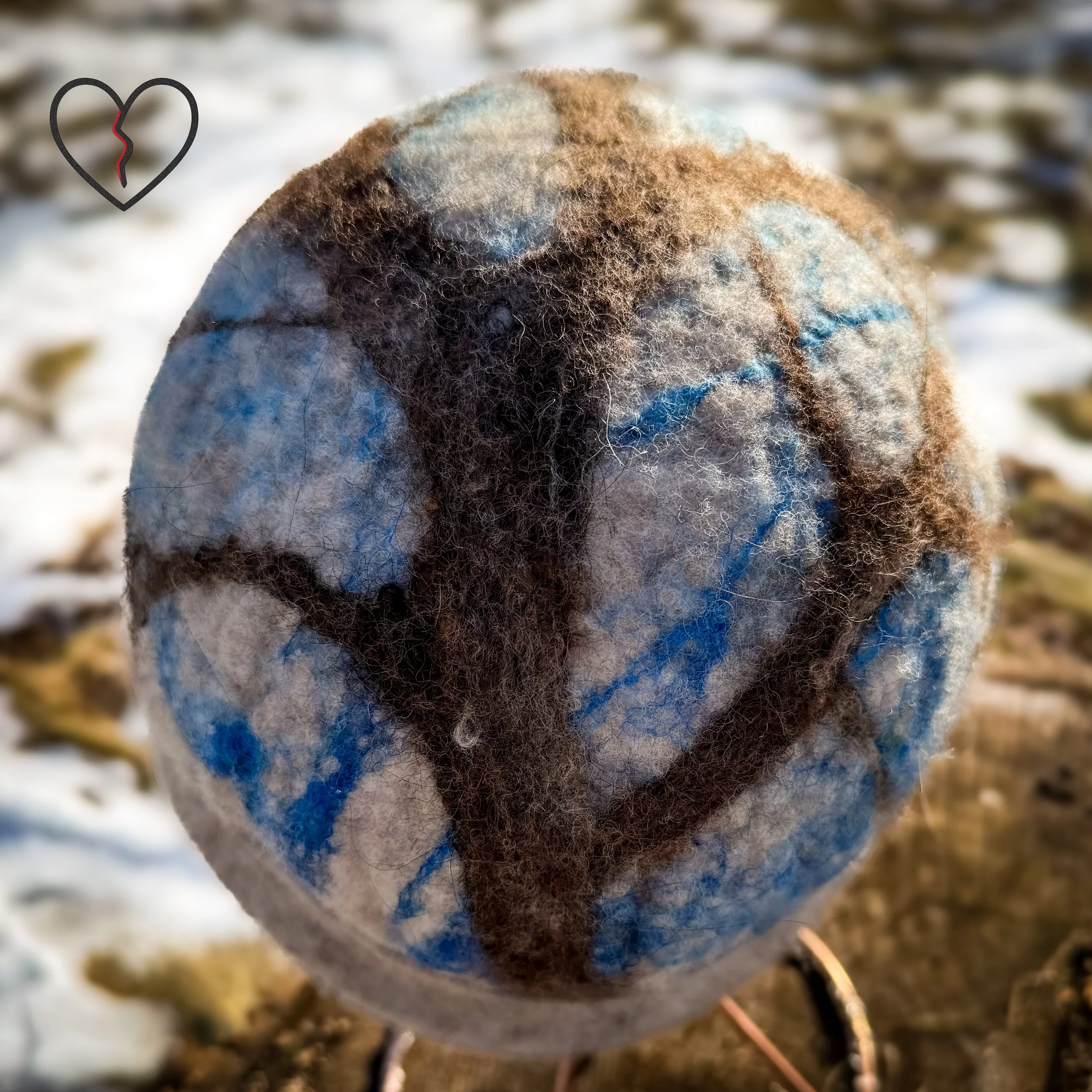 Back view of white wool felted hat with brown tree trunk rising upward into blue silk sky, symbolic grounded earth and mind wearable art