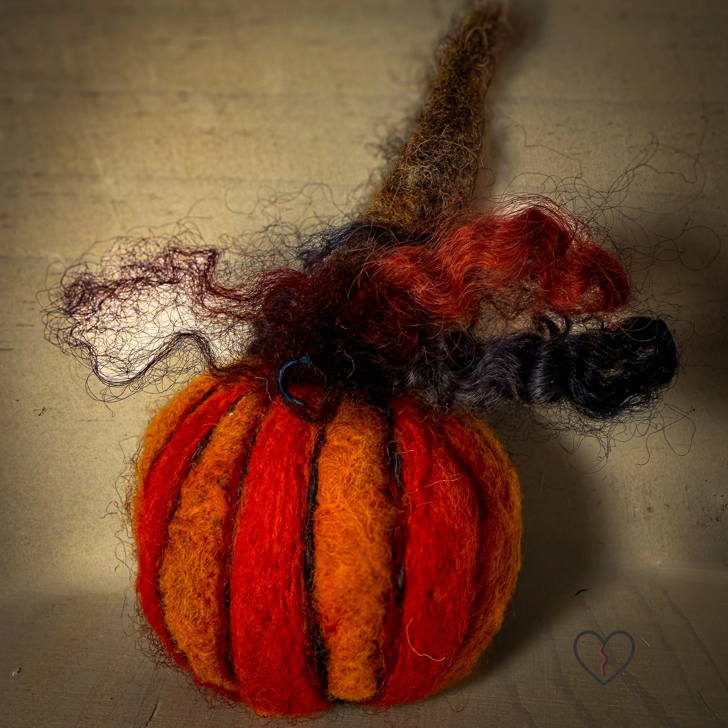 Handmade needle felted wool art pins arranged as a small collection, each approximately two inches square, featuring sculptural forms, layered fiber textures, and earthy, autumn-toned colors.