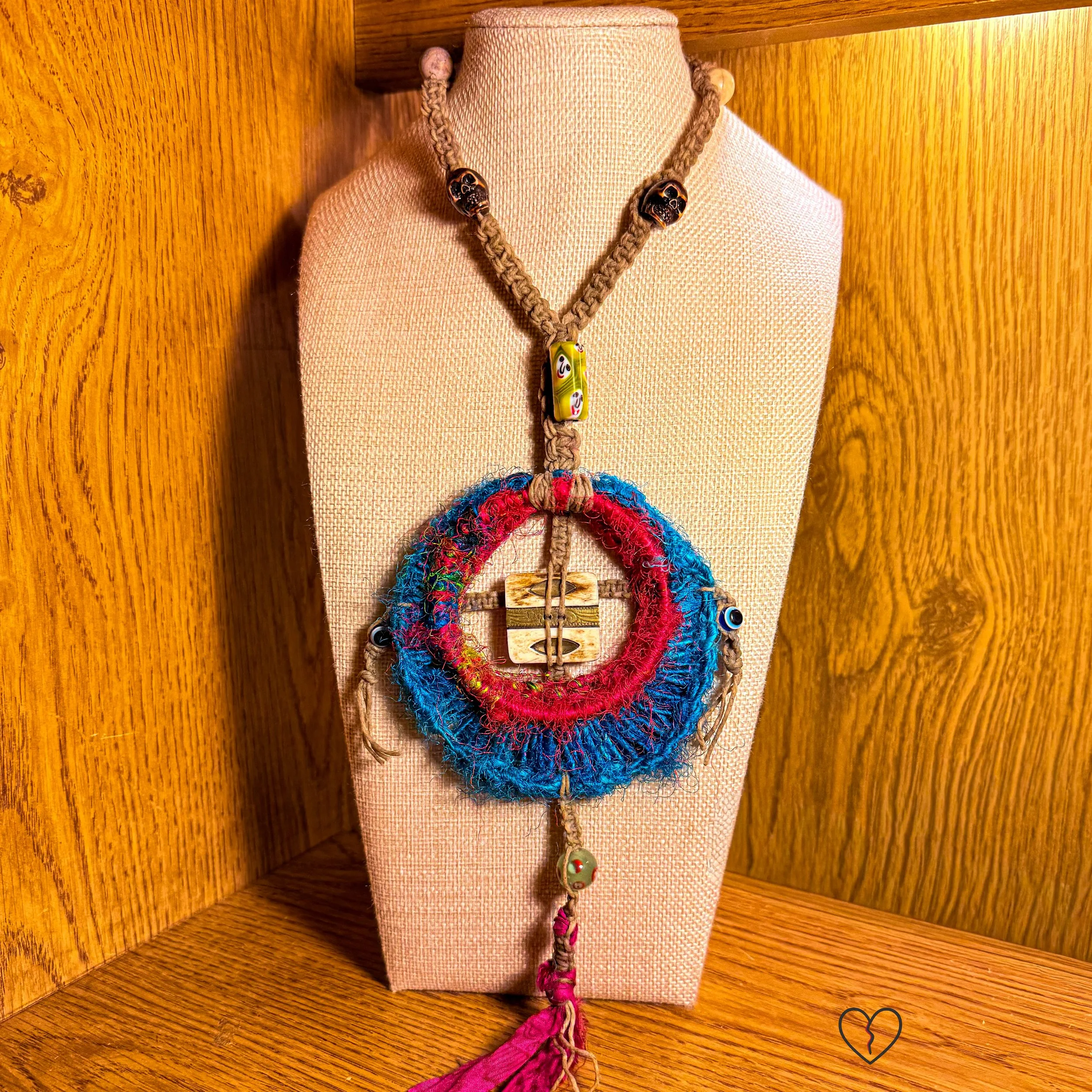 Circular sari silk pendant with red ring and blue crescent detail