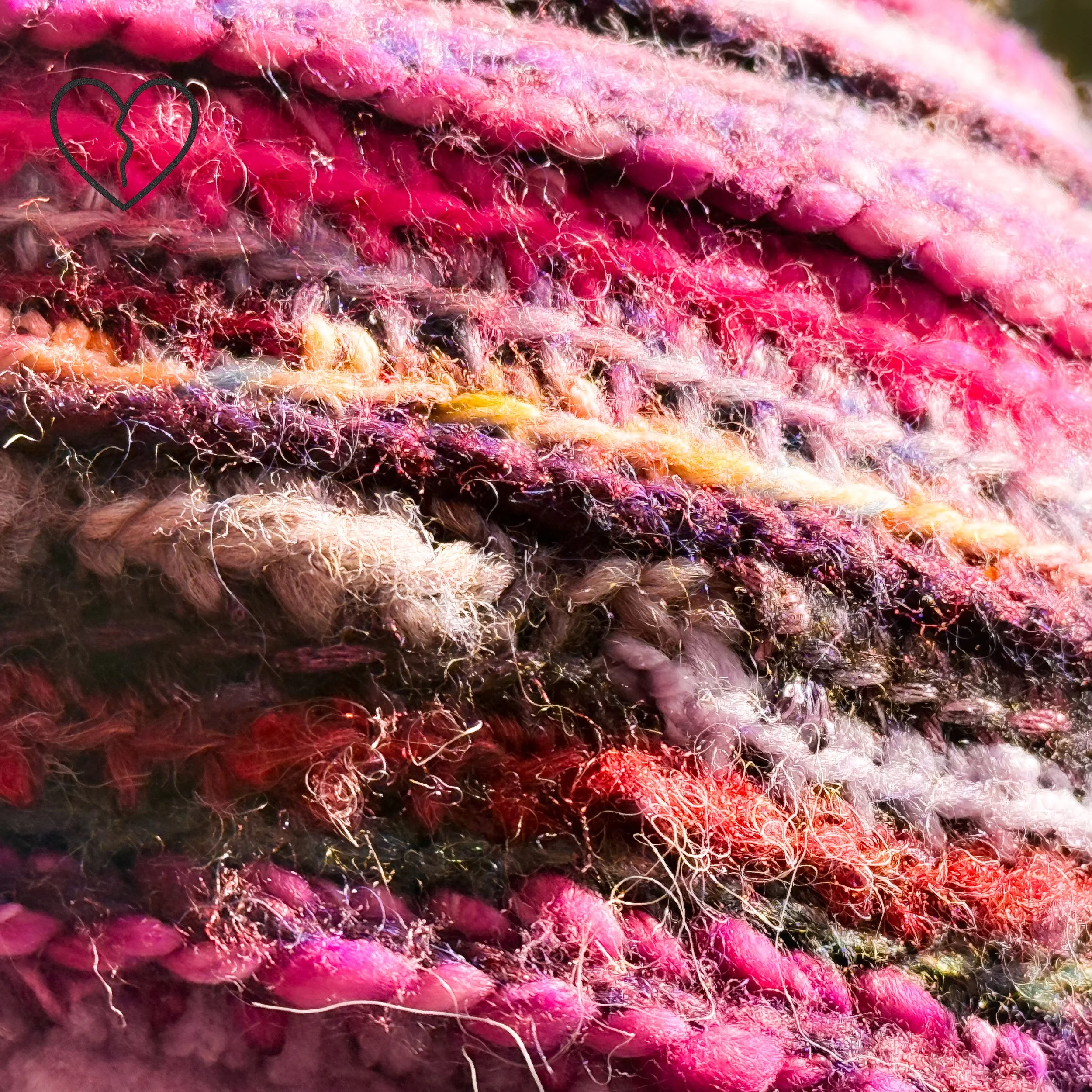 Back view of sculptural freeform crochet spiral hat in purple and magenta yarns with full ear coverage.