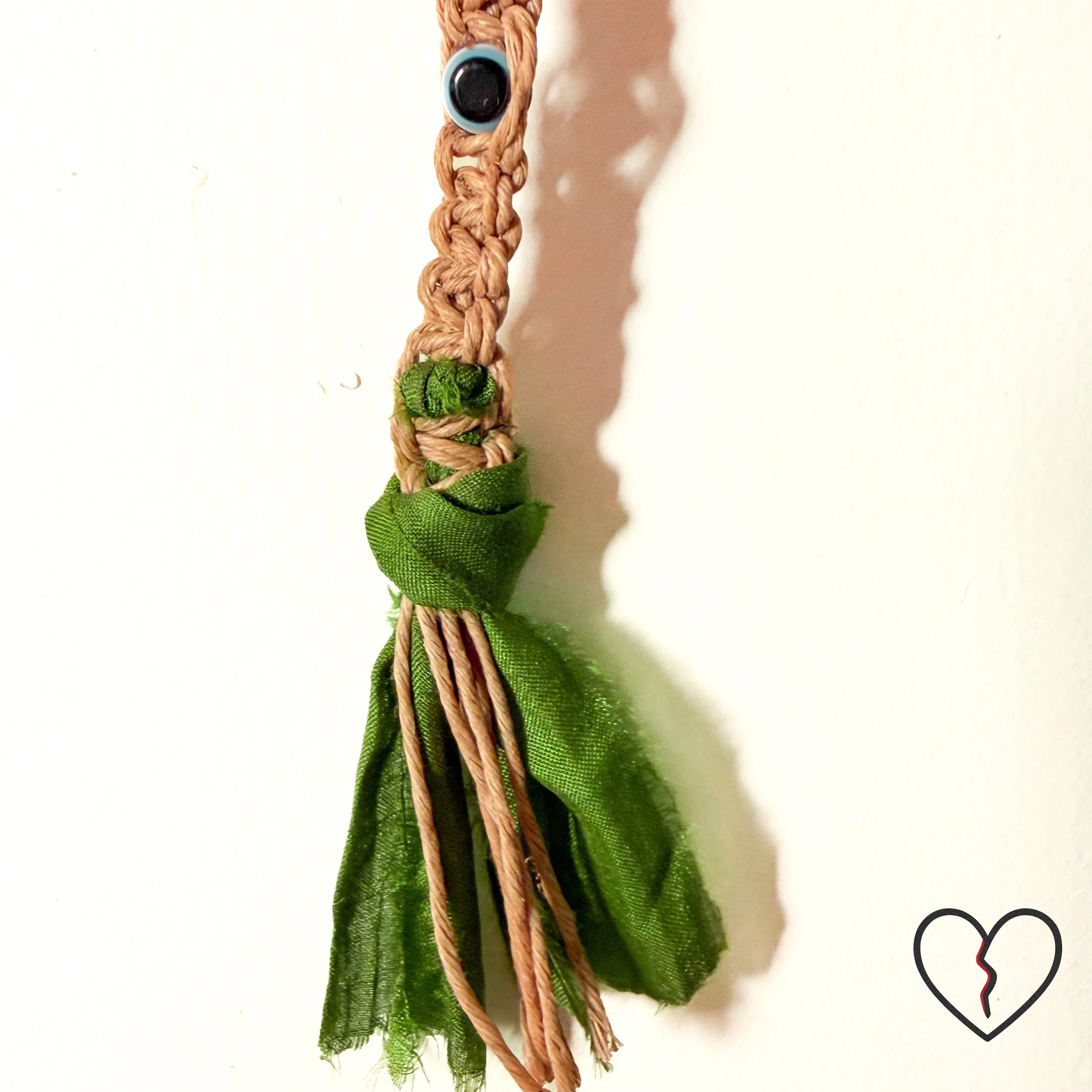 Deep blue protective bead set within macrame structure representing ancestral guardianship.