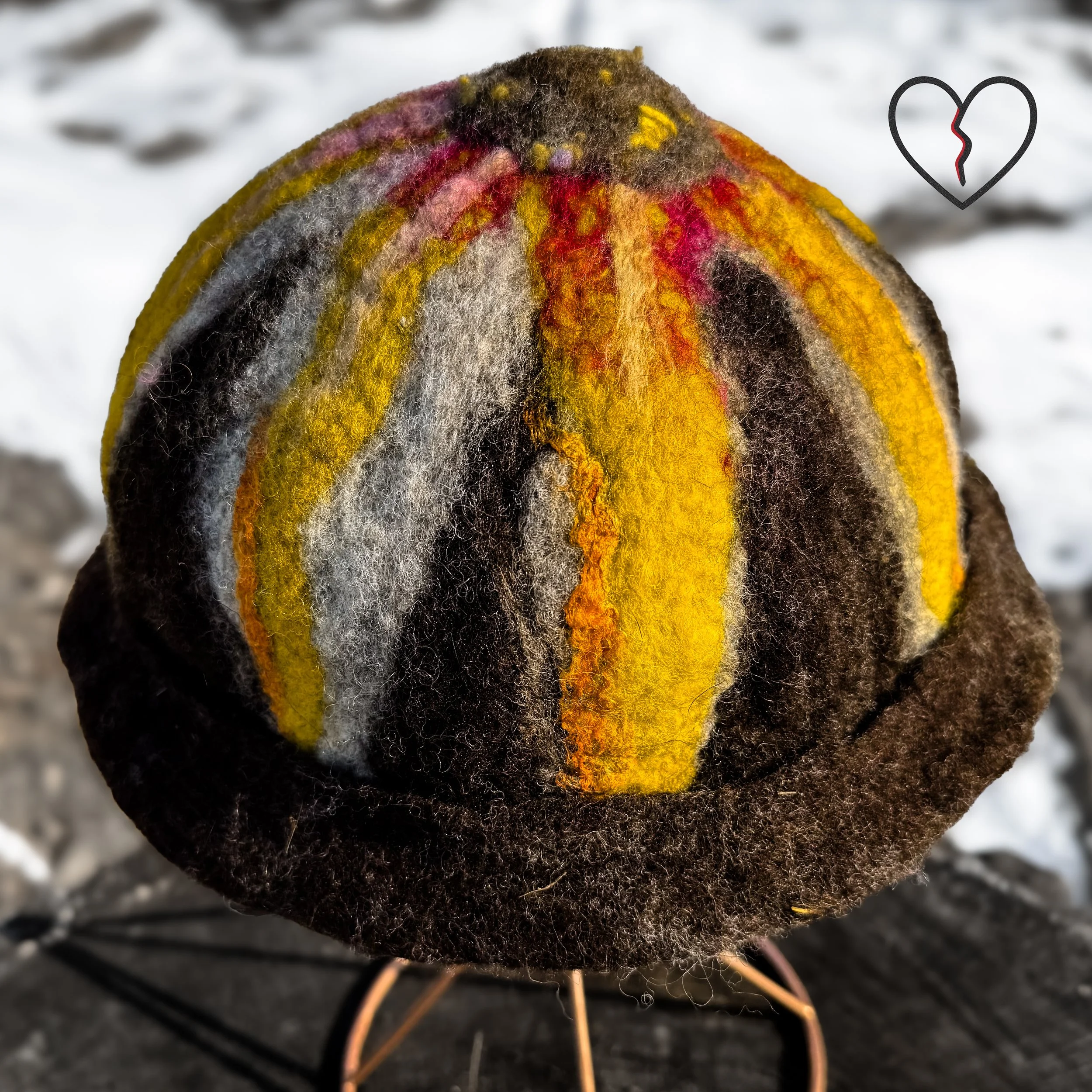 Side view of forest fairy acorn hat on stand showing folded brim and sculptural rounded form.