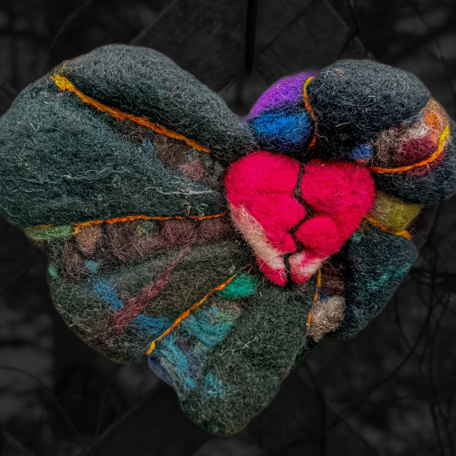 extured wool heart sculpture with a red heart breaking through.