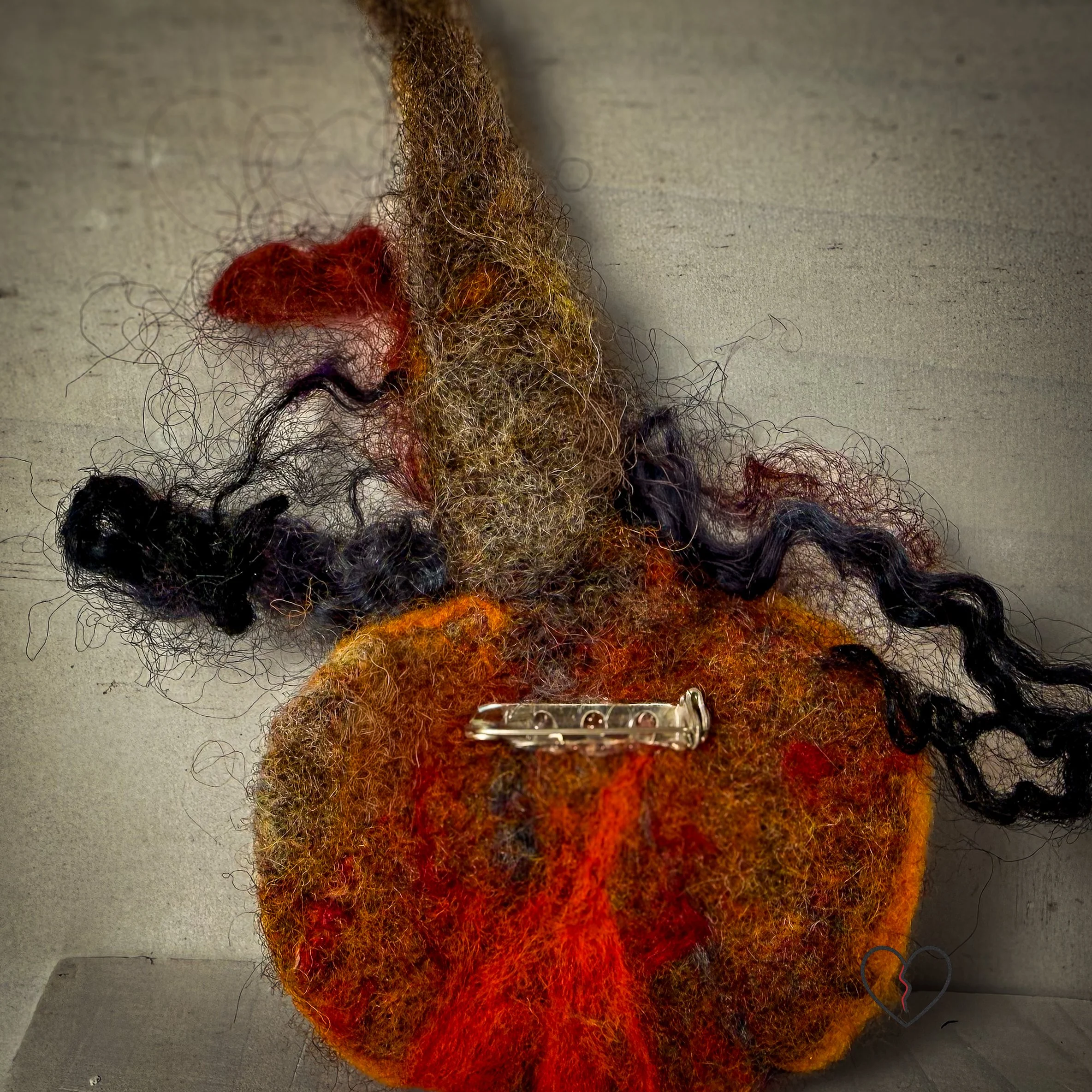 Handmade needle felted wool art pins arranged as a small collection, each approximately two inches square, featuring sculptural forms, layered fiber textures, and earthy, autumn-toned colors.