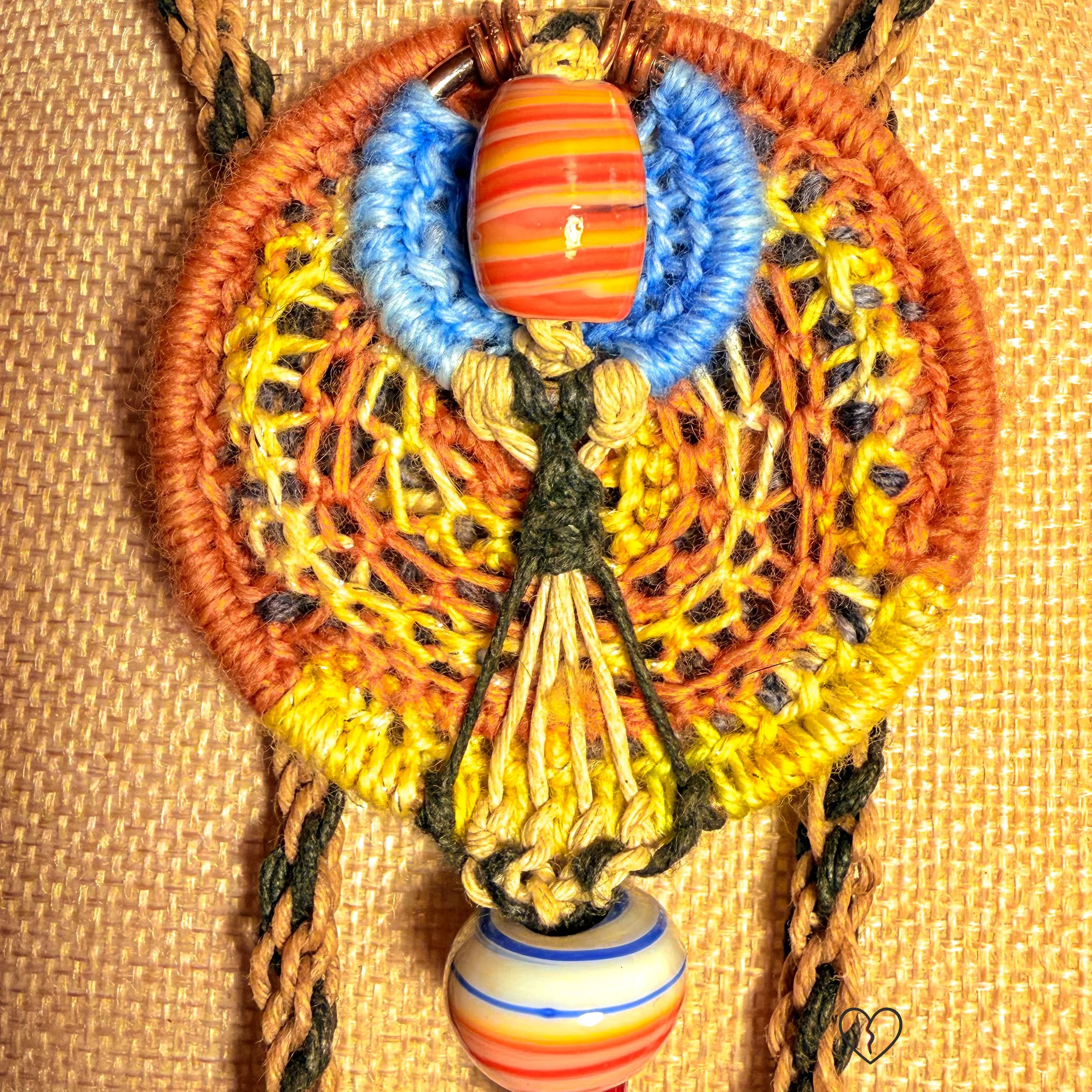 Fiber necklace with circular woven pendant and ceramic beads on kumihimo hemp cord