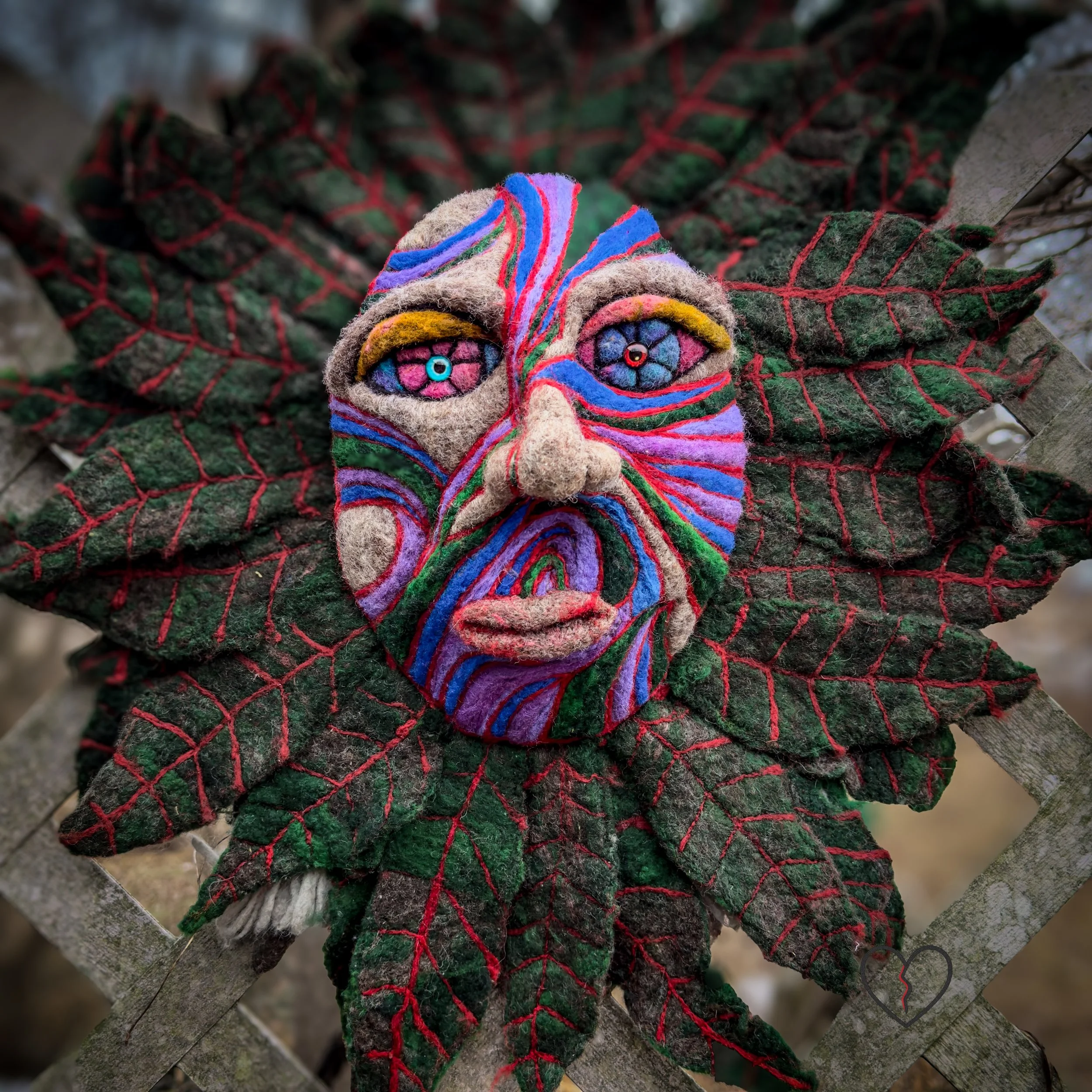 Wool nature spirit face with darkened leaves and red vein details