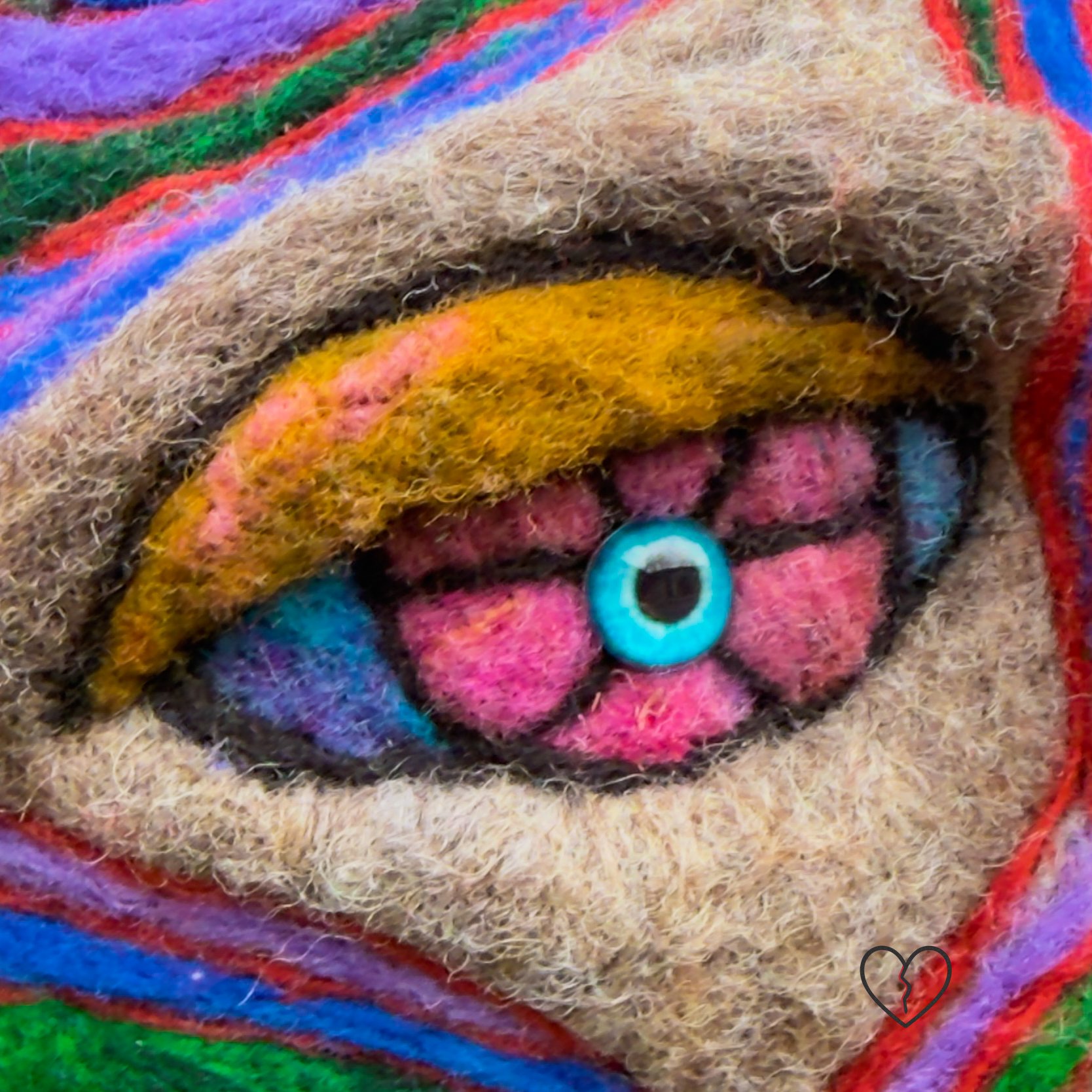 Close-up of needle-felted wool face showing reflective eyes