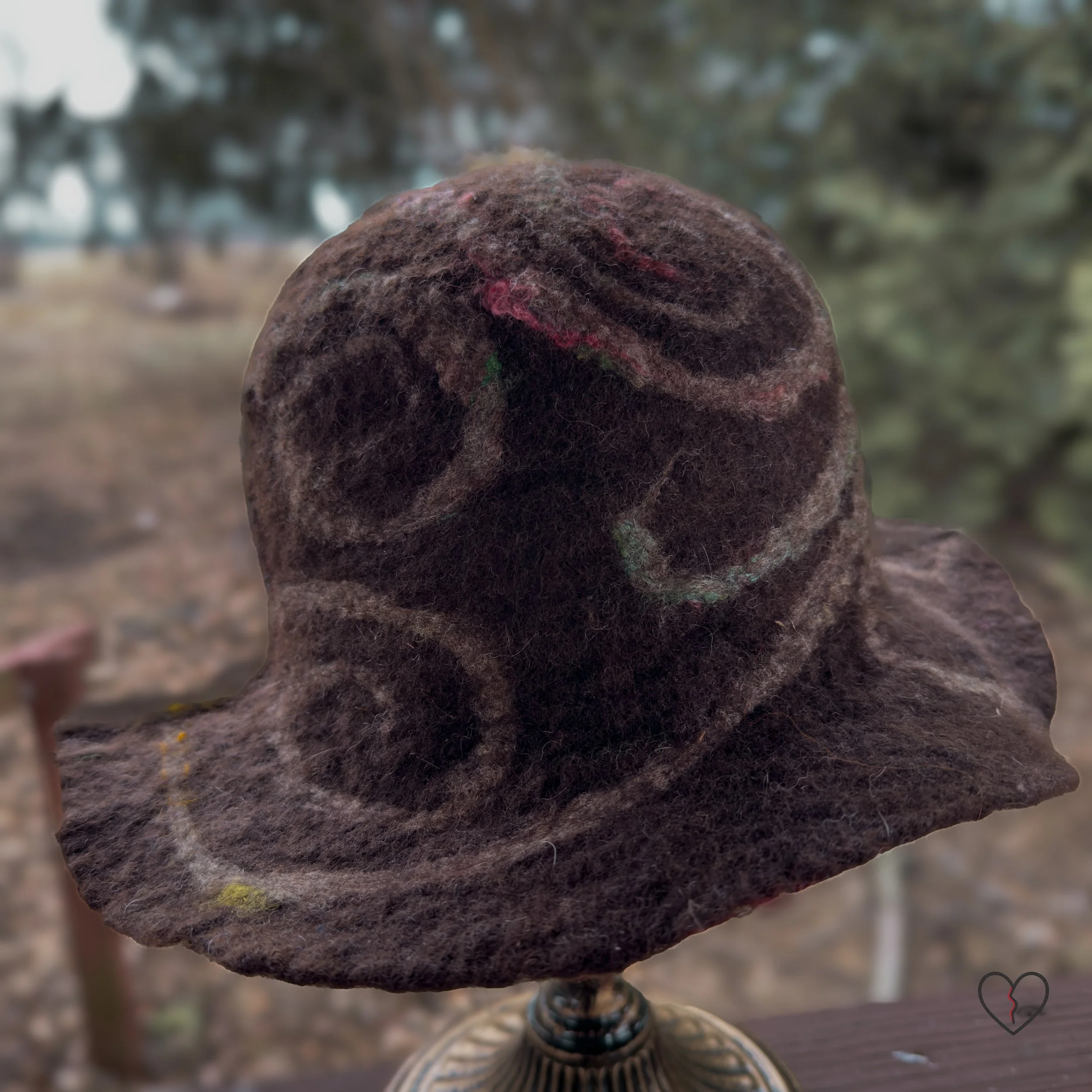 Back view of sturdy hand-felted wool hat with organic swirl patterns