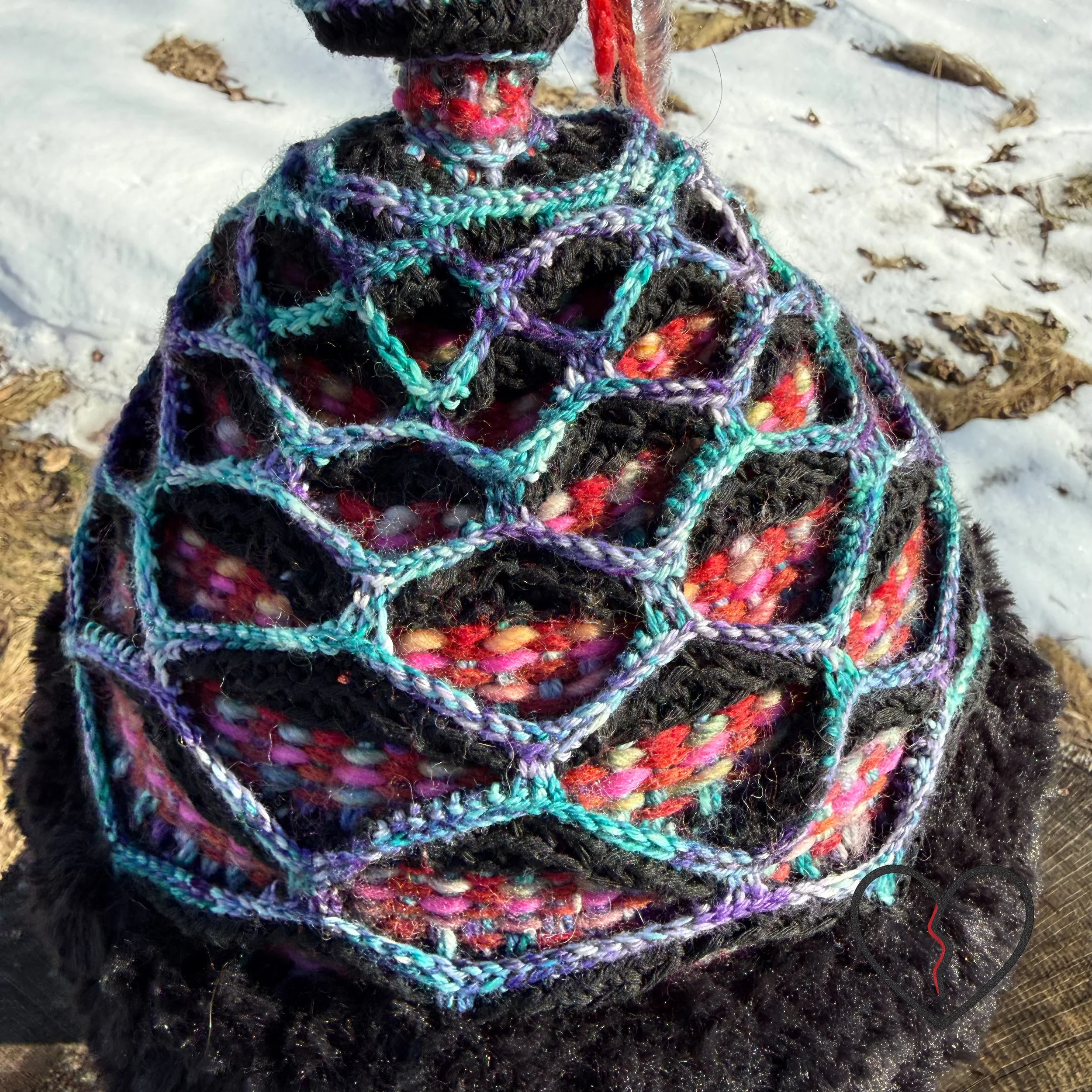 Artistic fiber headpiece featuring woven wool color, crochet lattice armor structure, and faux fur trim, symbolic of nomadic leadership.