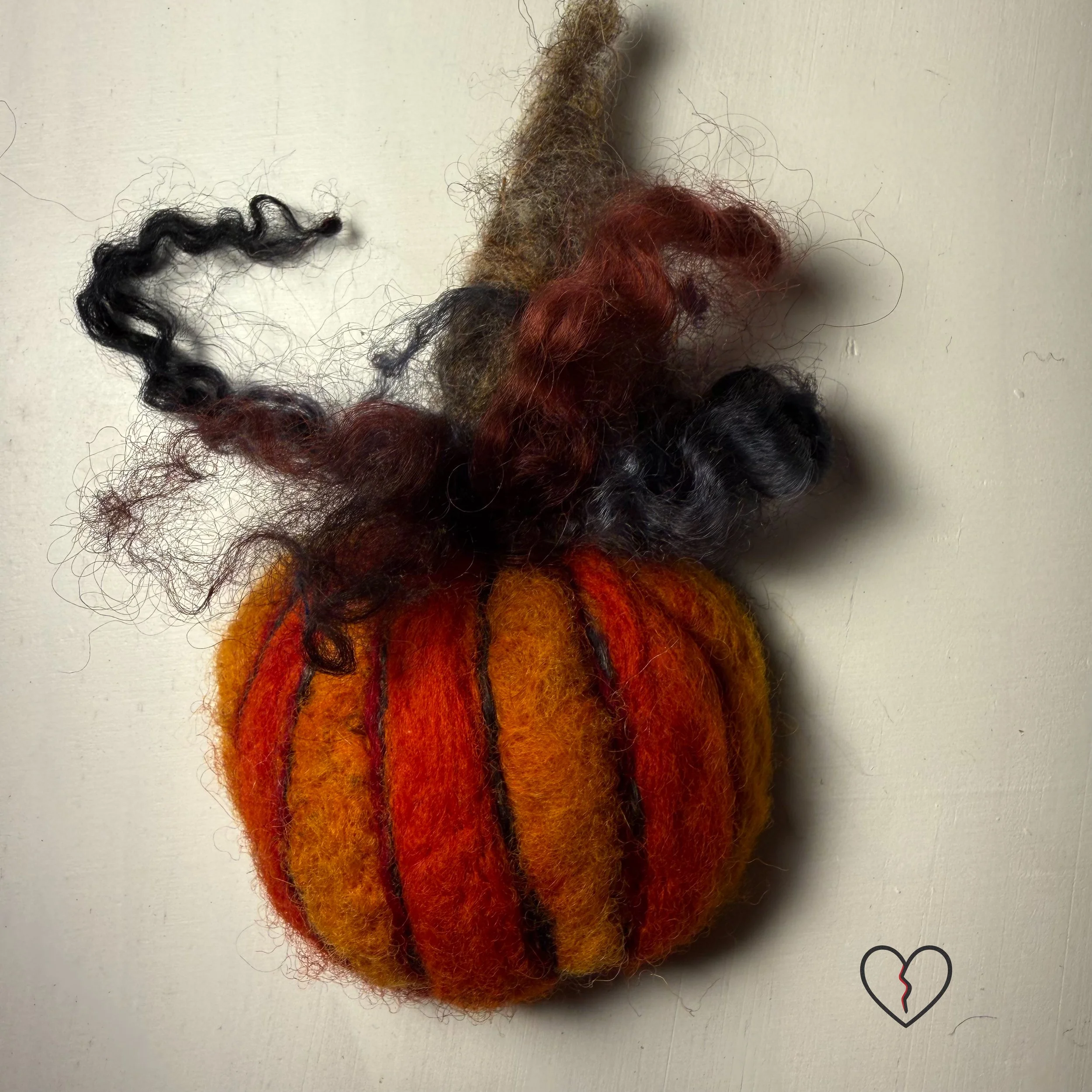 Handmade needle felted wool art pins arranged as a small collection, each approximately two inches square, featuring sculptural forms, layered fiber textures, and earthy, autumn-toned colors.