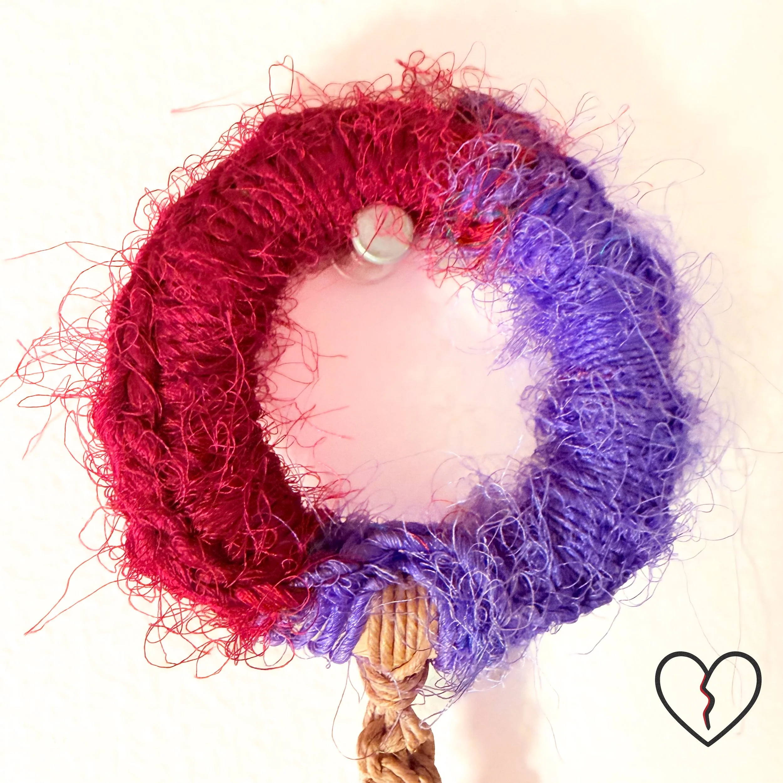 Lower tassel with silk fibers and glass evil eye bead for spiritual protection.