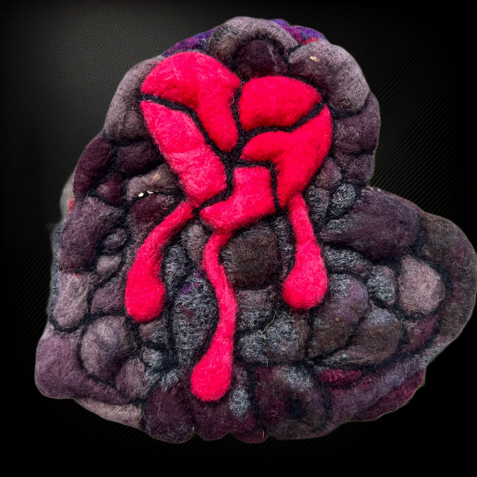 Hand-felted wool broken heart wall art with bleeding red heart and stone-textured background