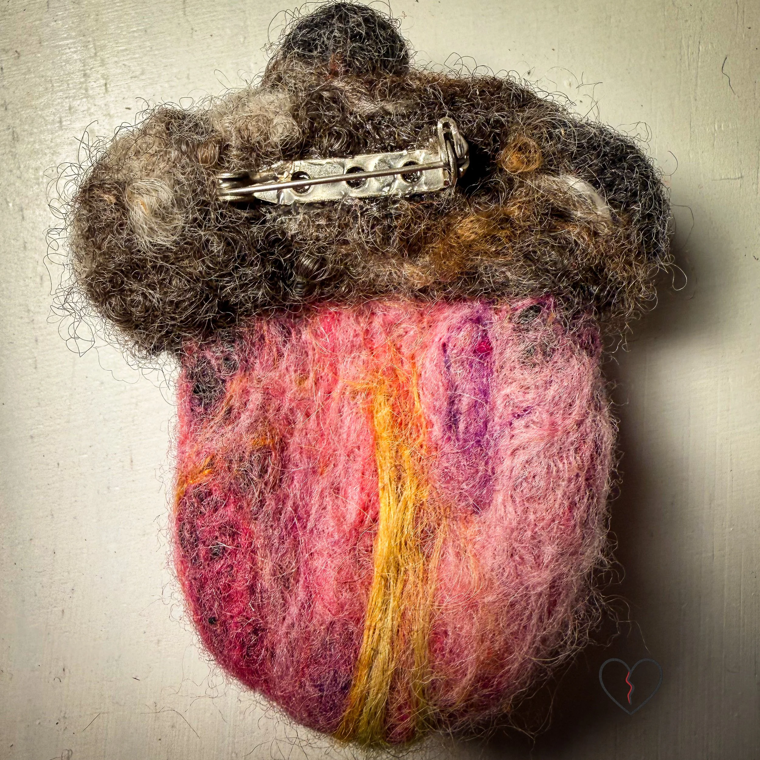 A group of handmade needle felted wool art pins, each one of a kind, showing organic shapes, soft sculptural texture, and layered wool fibers in muted seasonal tones.