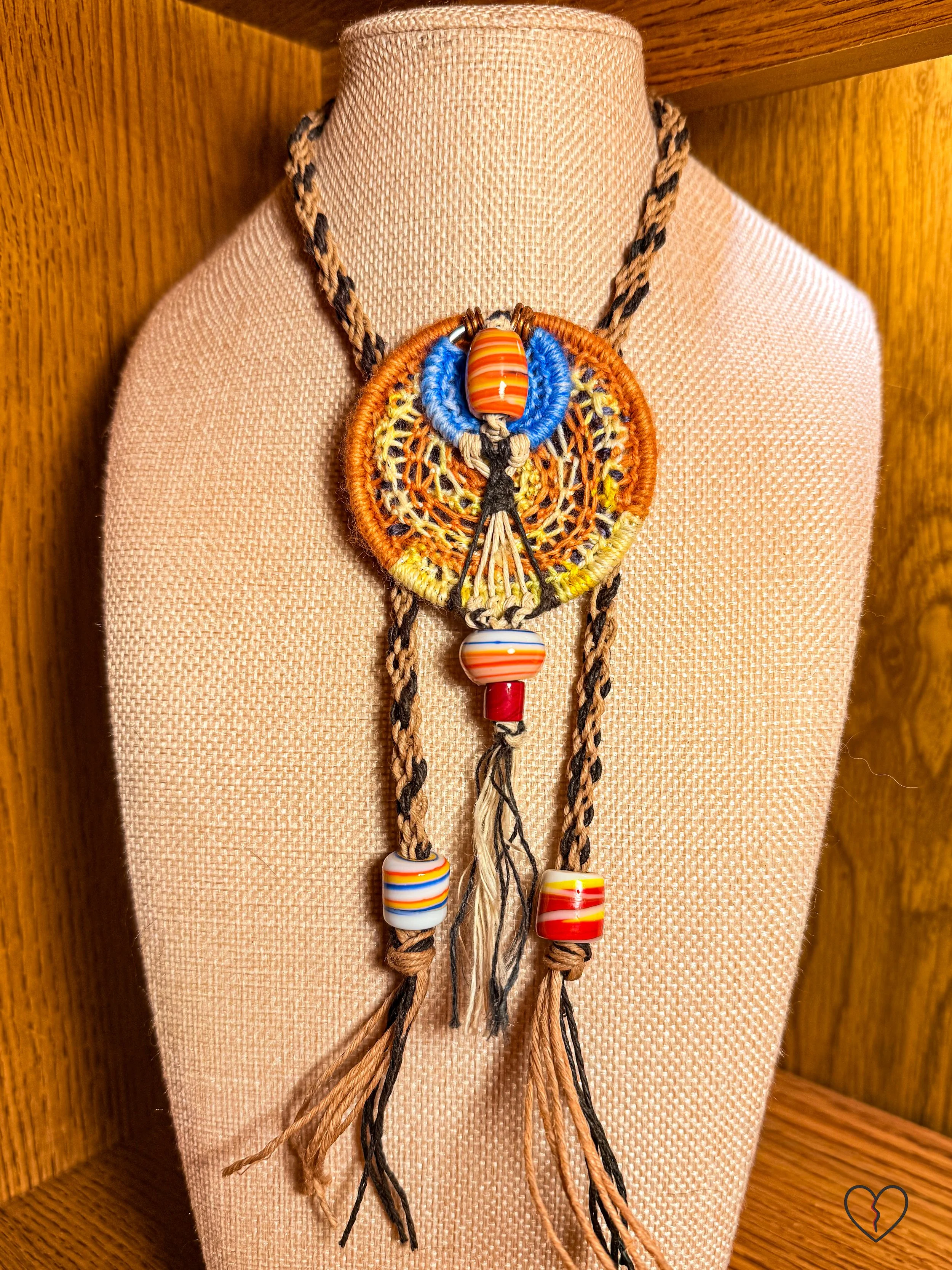 Fiber necklace with circular woven pendant and ceramic beads on kumihimo hemp cord