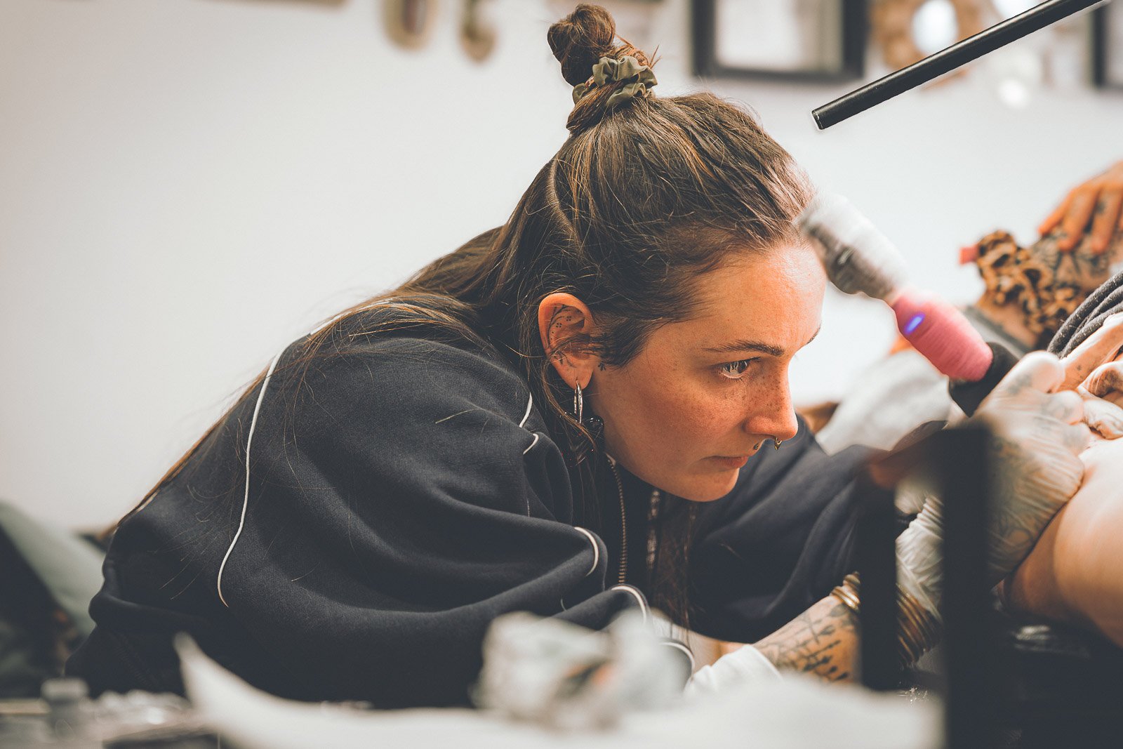 Tatoueuse concentrée pendant une séance de tatouage à Gannat
