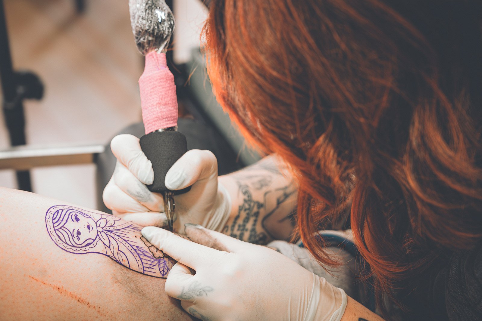 Tatoueuse travaillant sur un tatouage dans un salon à Gannat
