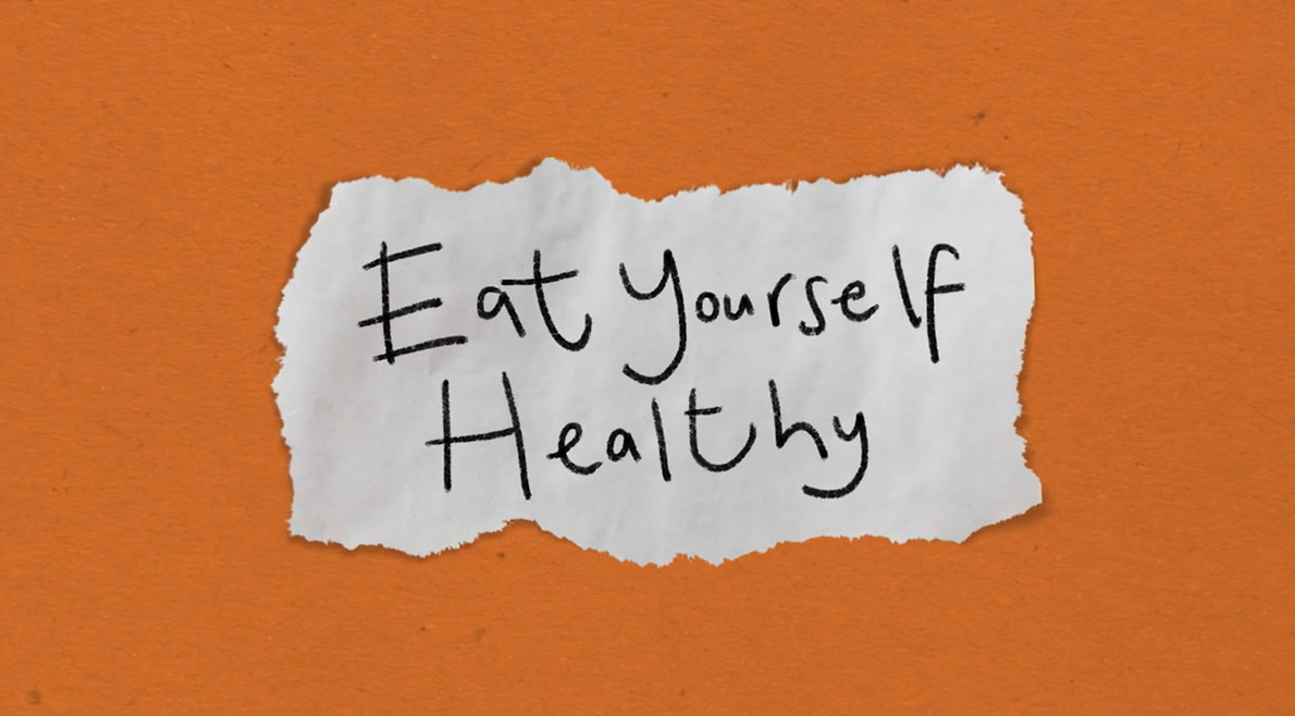 A torn piece of white paper on an orange background with the handwritten message "Eat Yourself Healthy" in black ink.