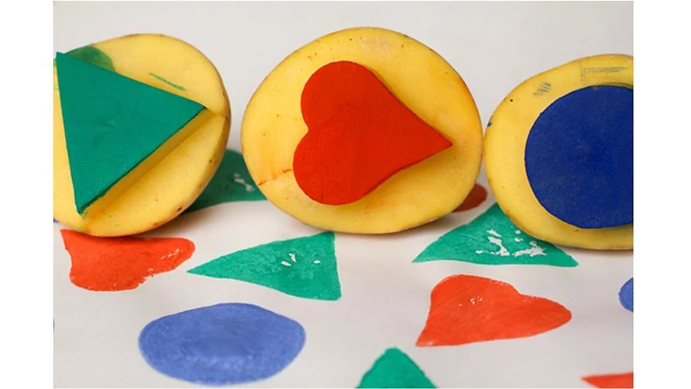 Three bananas with colorful shapes inside, on a white surface with painted colorful shapes.