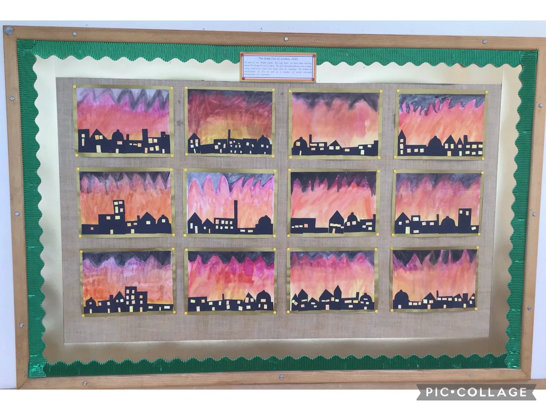 A bulletin board display featuring 15 paintings of sunsets over various city skylines, with dark silhouettes of buildings against colorful, cloudy skies.